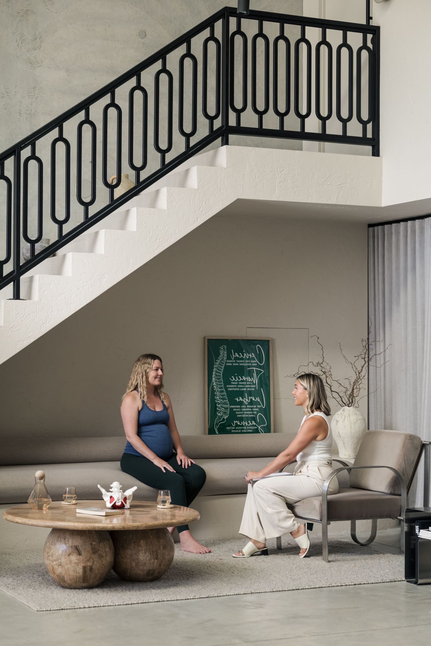 Interior lifestyle photos showing a relaxed scene under stairs with modern decor and natural lighting.