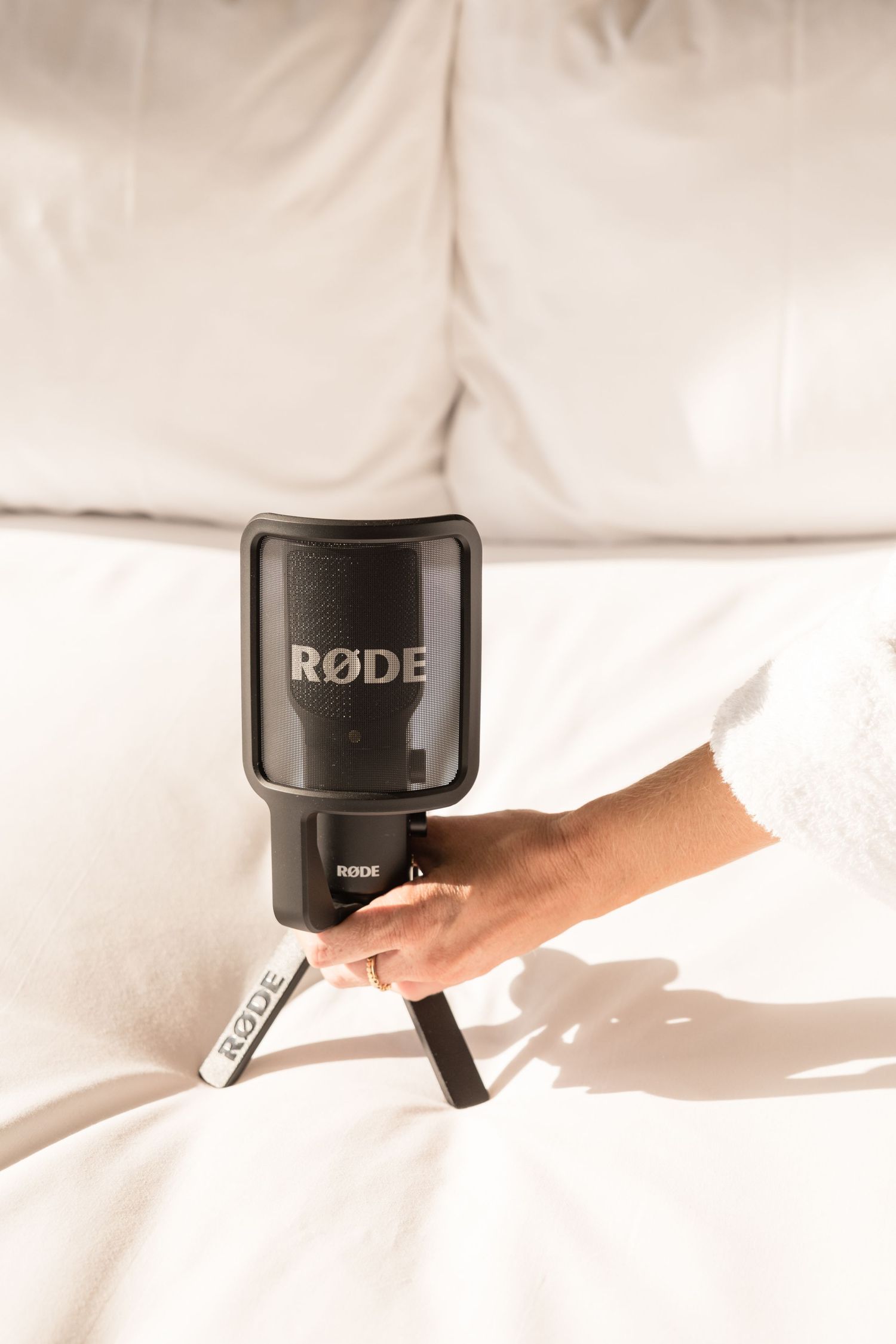 A Rode camera flash unit being held against a white background.