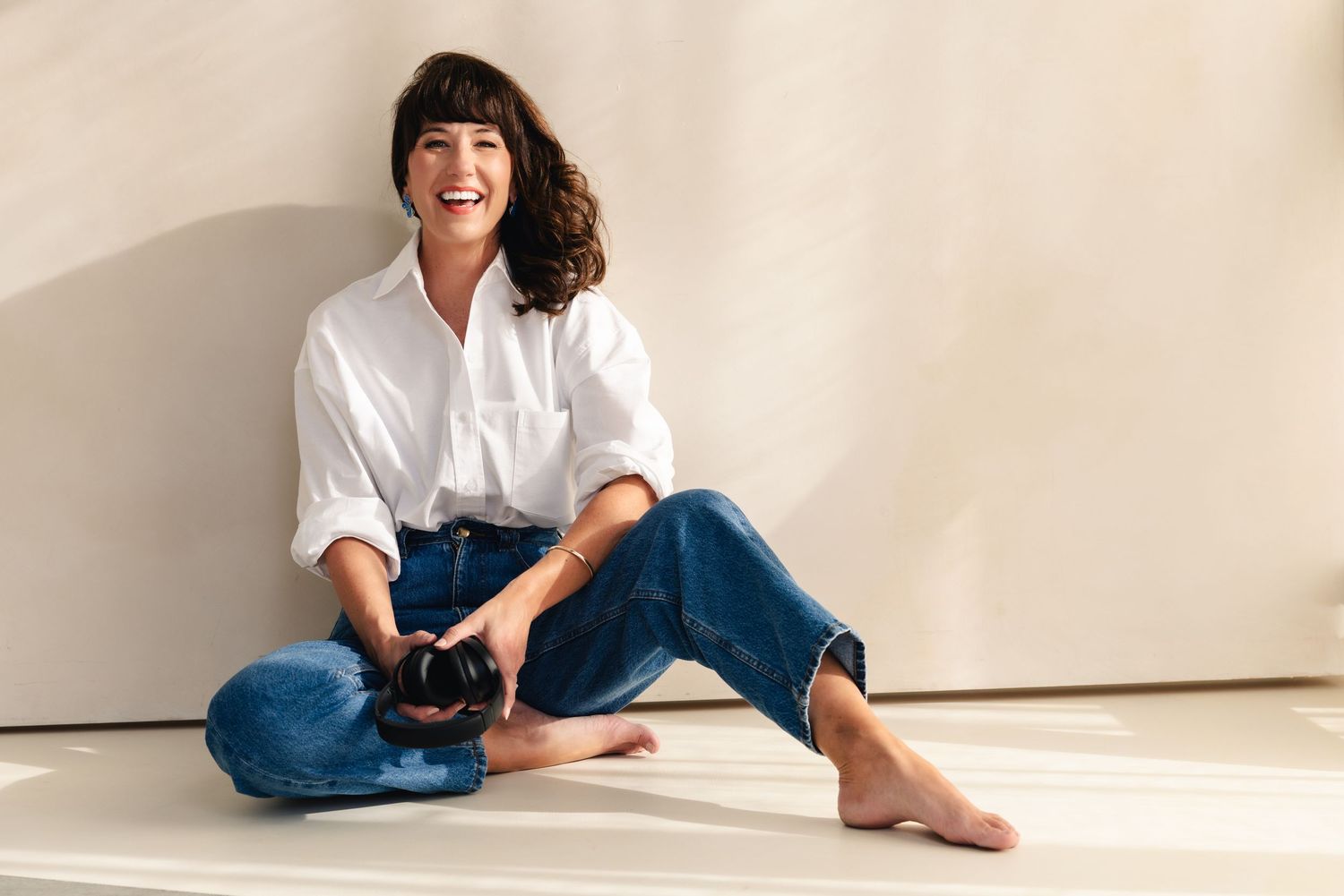 Relaxed lifestyle photos in casual white shirt and denim on light background.