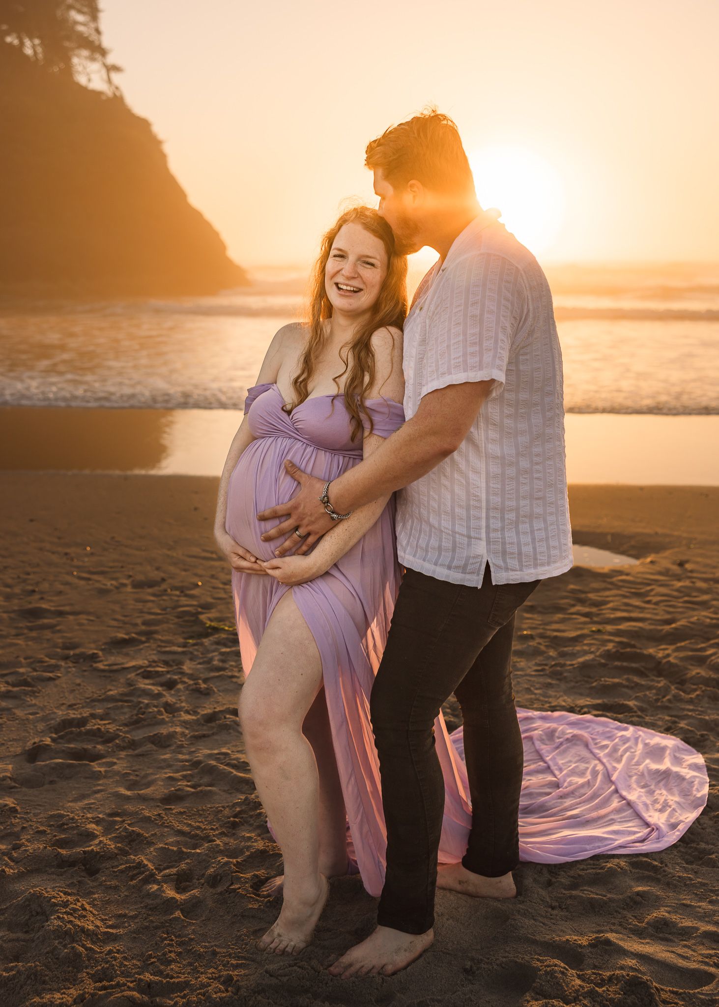 A couple embraces on a sandy beach at sunset during a photo session taken by Salem, Oregon maternity photographer.