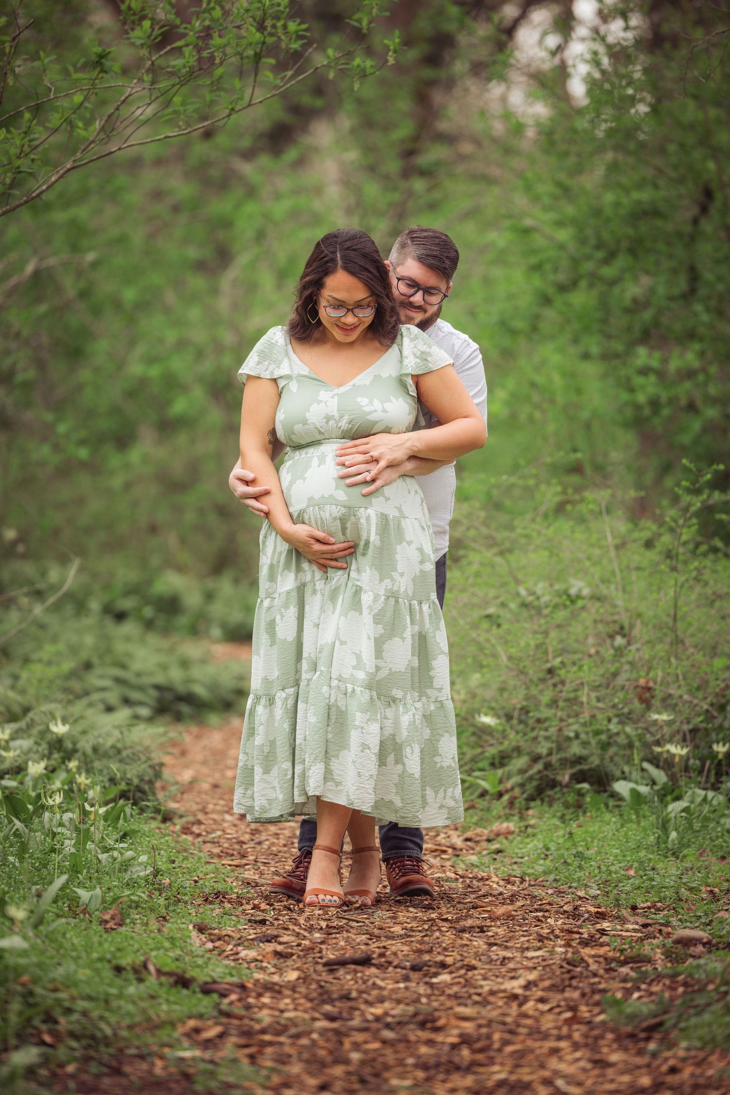 Sweet couple sharing tender moments along a woodland path taken by Salem, Oregon maternity photographer.