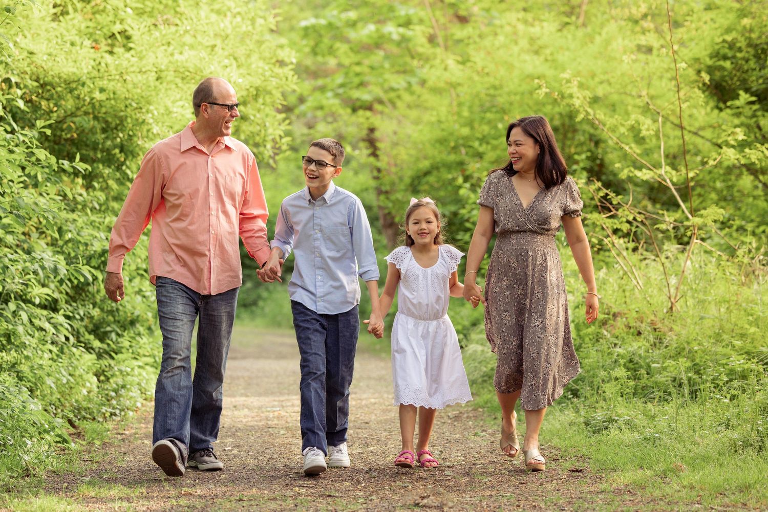 Family of four walking together on a nature trail during a photo session with Salem, Oregon family photographer.