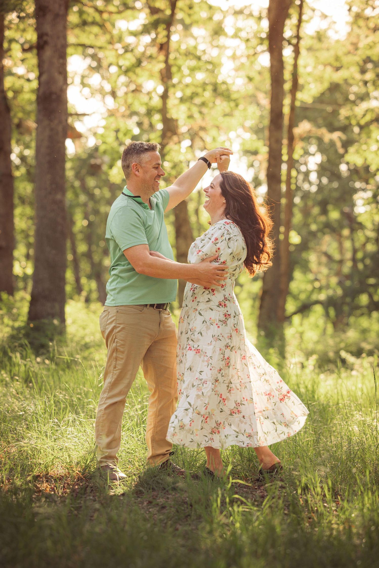 Couple dancing together in a sun-lit forest clearing during a romantic photo session with Salem, Oregon family photographer.