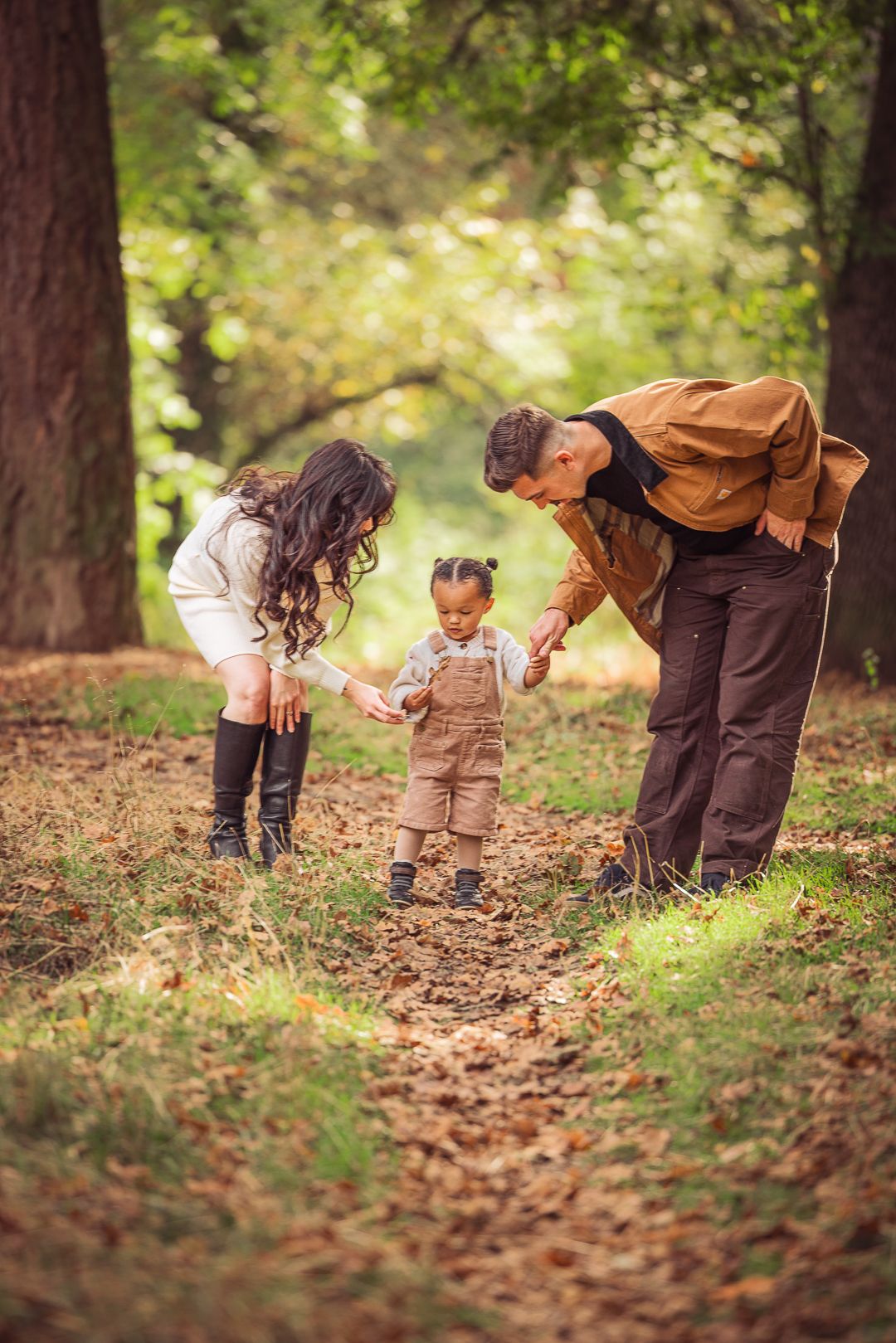 Parent and child explore nature together on a leaf-covered forest path taken by Salem, Oregon family photographer.