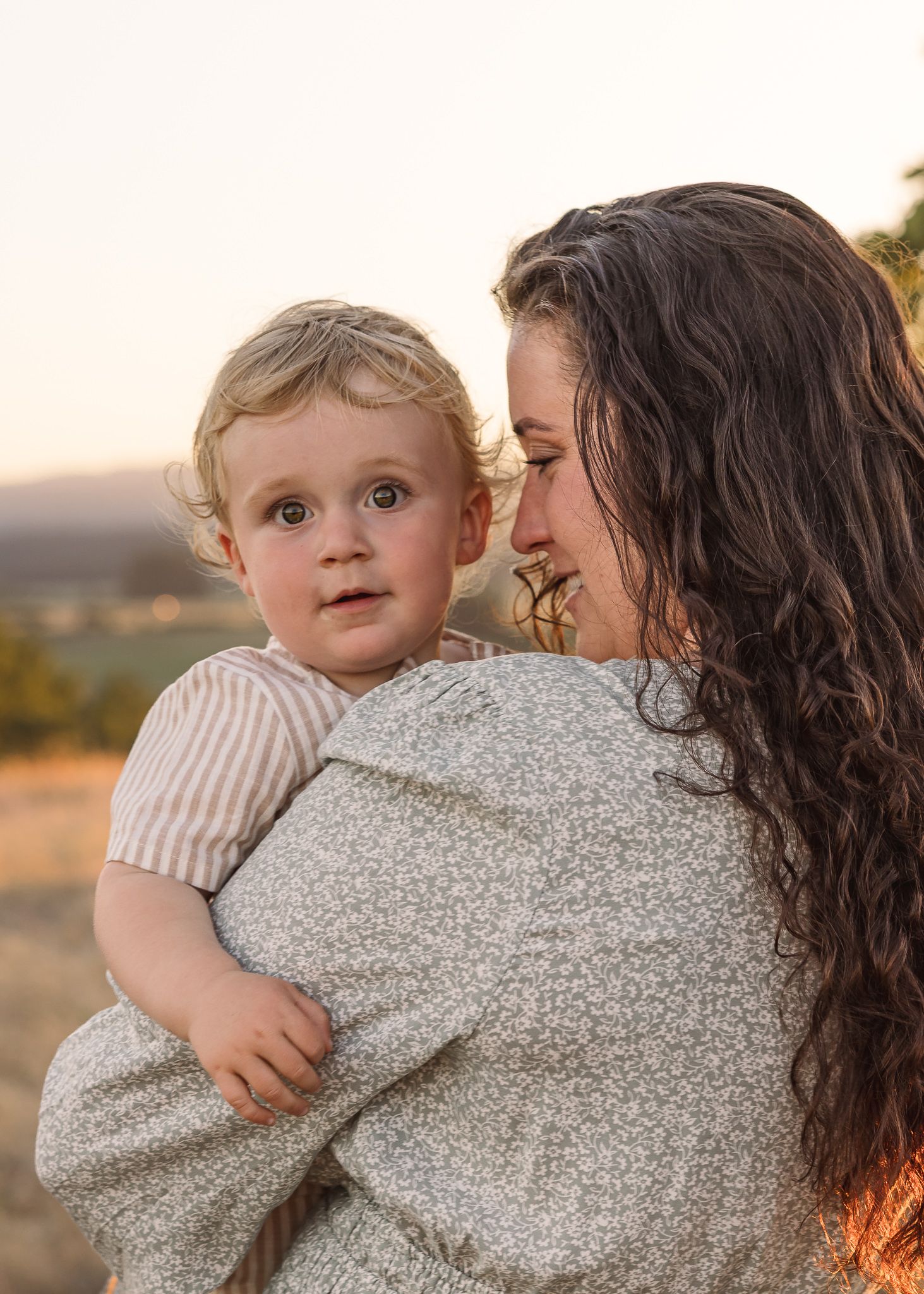 Tender moments between parent and child during sunset photoshoot in a field taken by Salem, Oregon family photographer.
