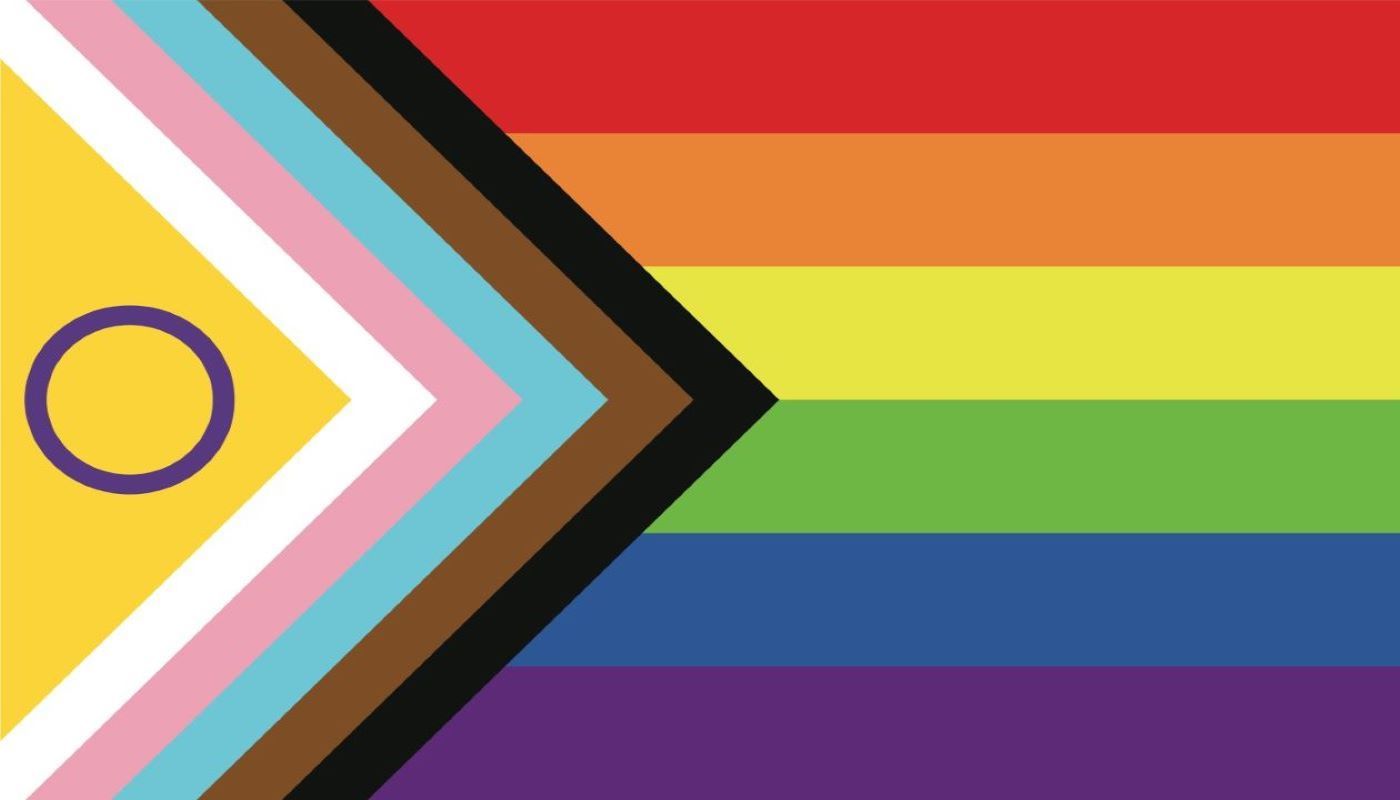 Progress pride flag featuring rainbow stripes with additional chevron of inclusive colors.
