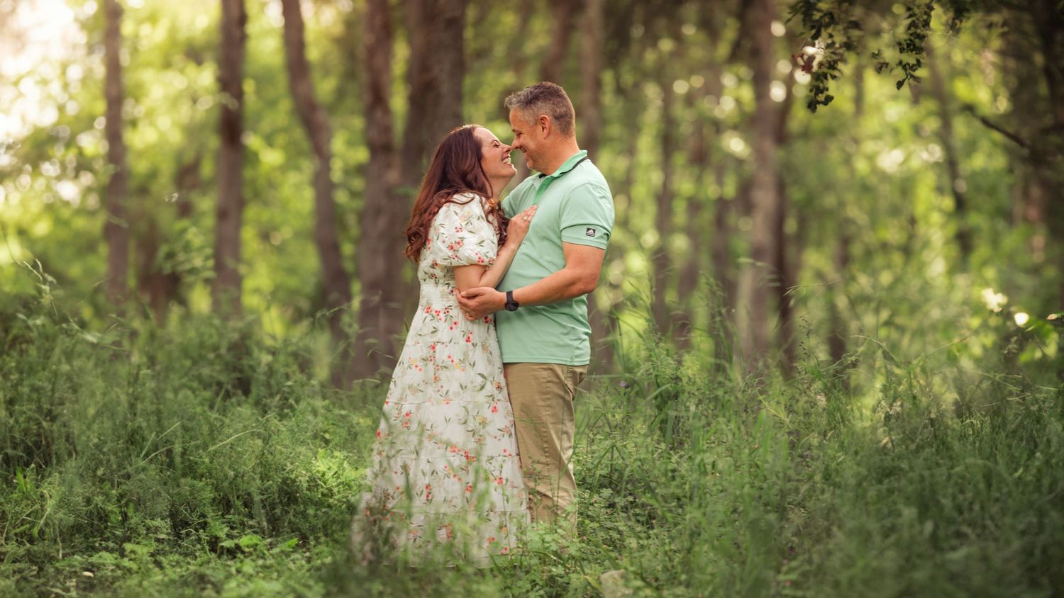 Photo of a couple sharing intimate moments in a sunlit forest setting taken by Salem, Oregon family photographer.