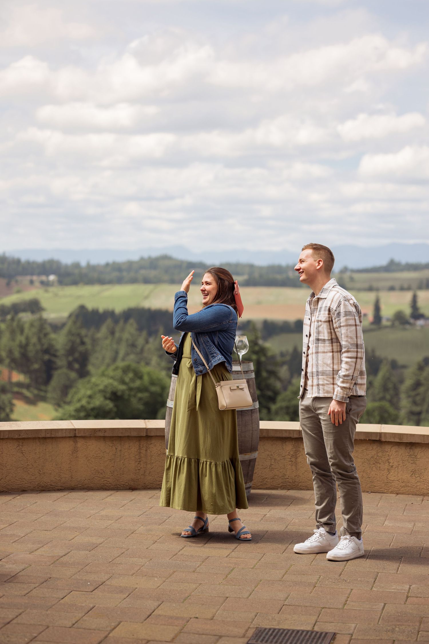 Couple enjoying scenic mountain views from a stone observation deck on a cloudy California afternoon.