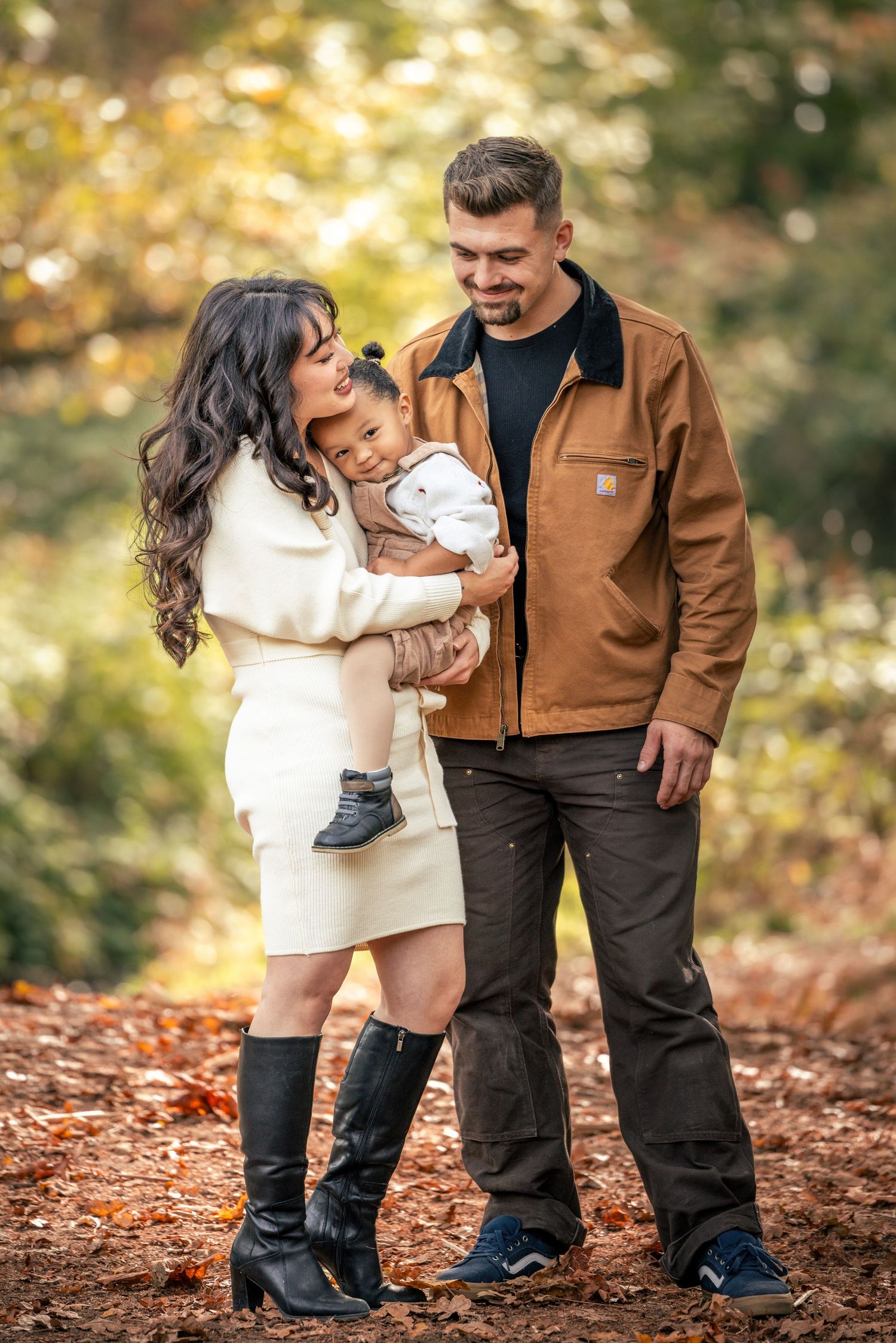 Family enjoying autumn fun on fallen leaves in a forest setting taken by Salem, Oregon family photographer.