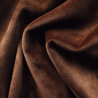 Soft brown velvet fabric with elegant folds and draping creates a luxurious textured surface.