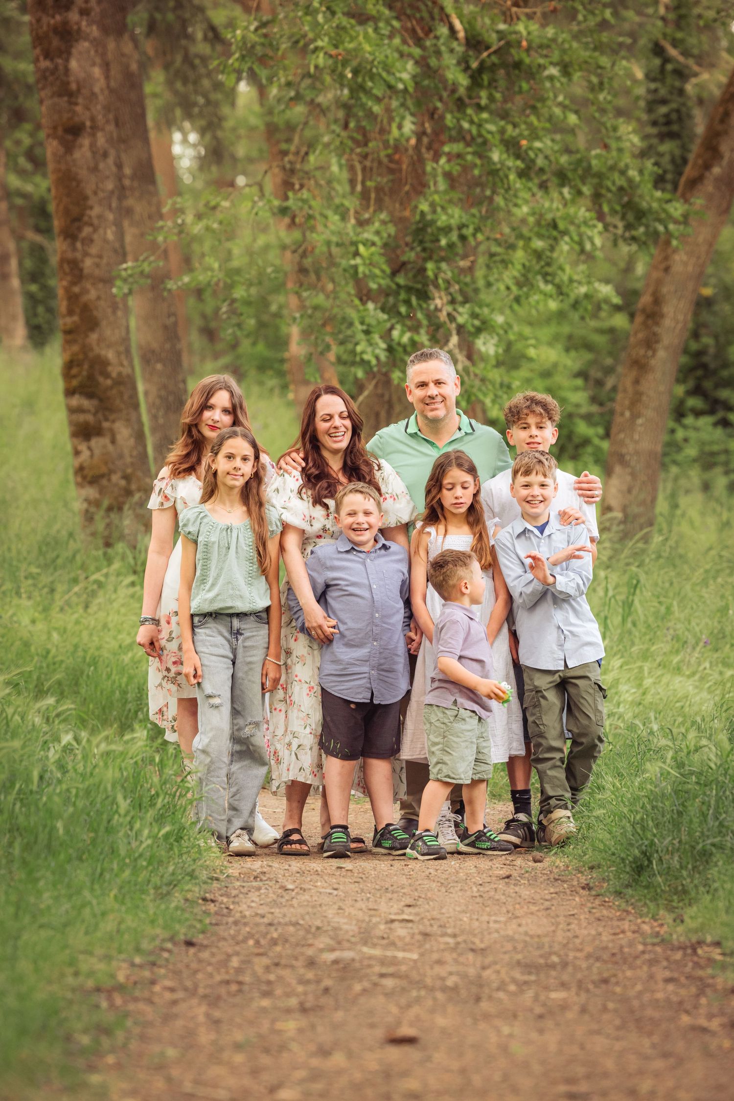 A happy group enjoying a pleasant walk together on a wooded dirt path during a bright sunny day.