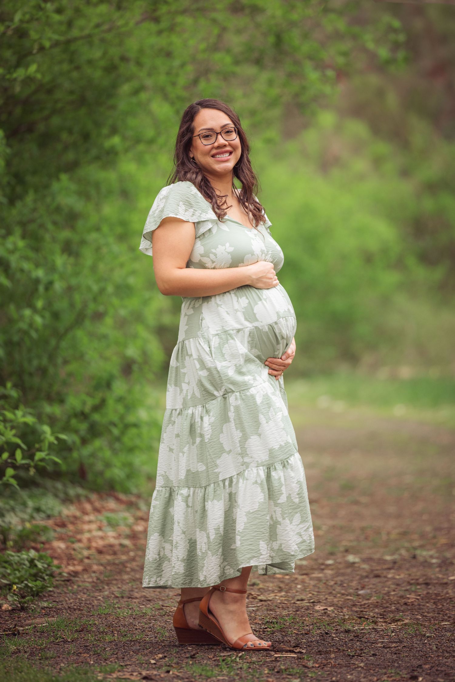 Woman in flowy mint dress posing gracefully on a forest trail taken by Salem, Oregon maternity photographer.