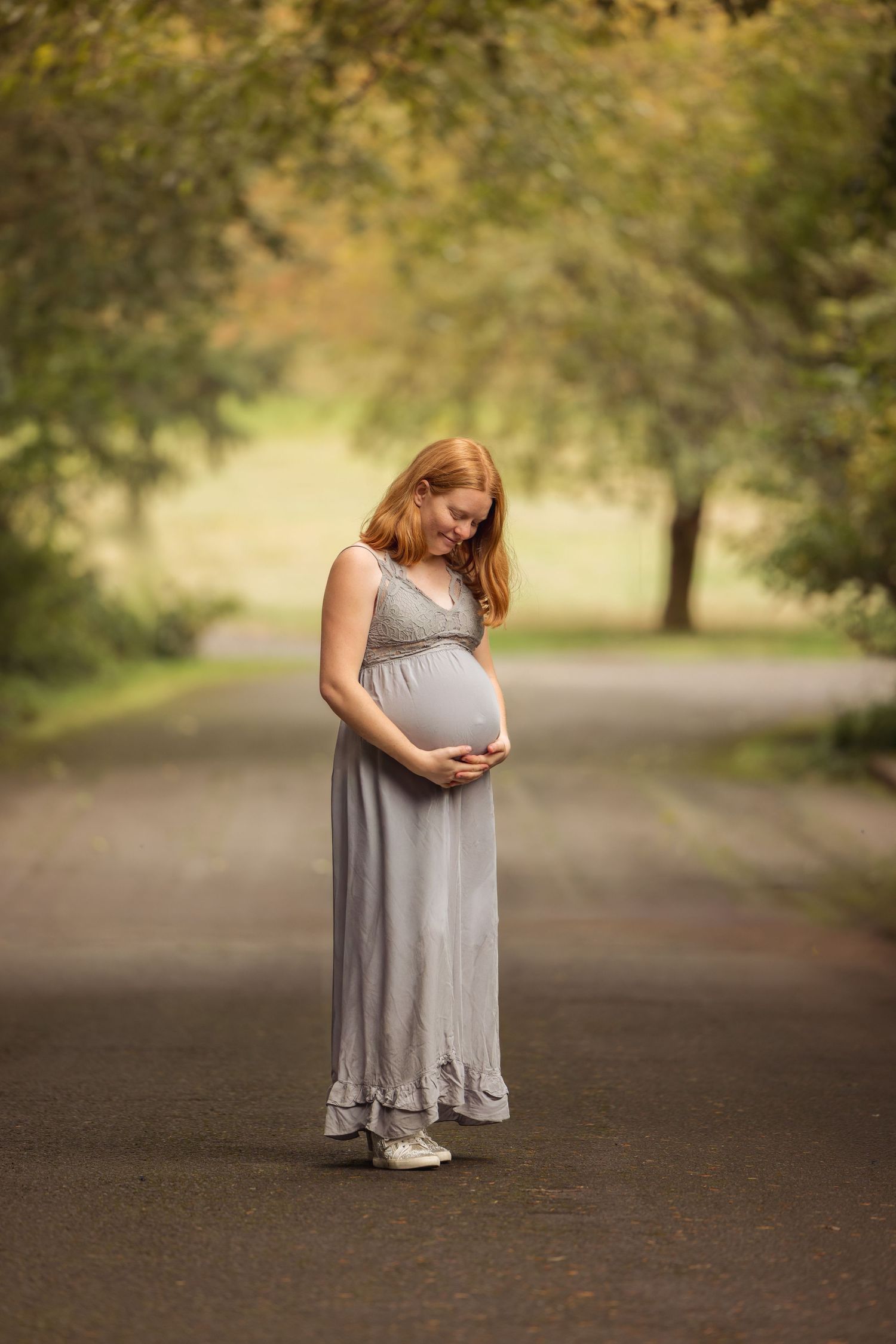 A maternity photo progression shows a woman in a grey dress cradling her growing belly through five stages of pregnancy.