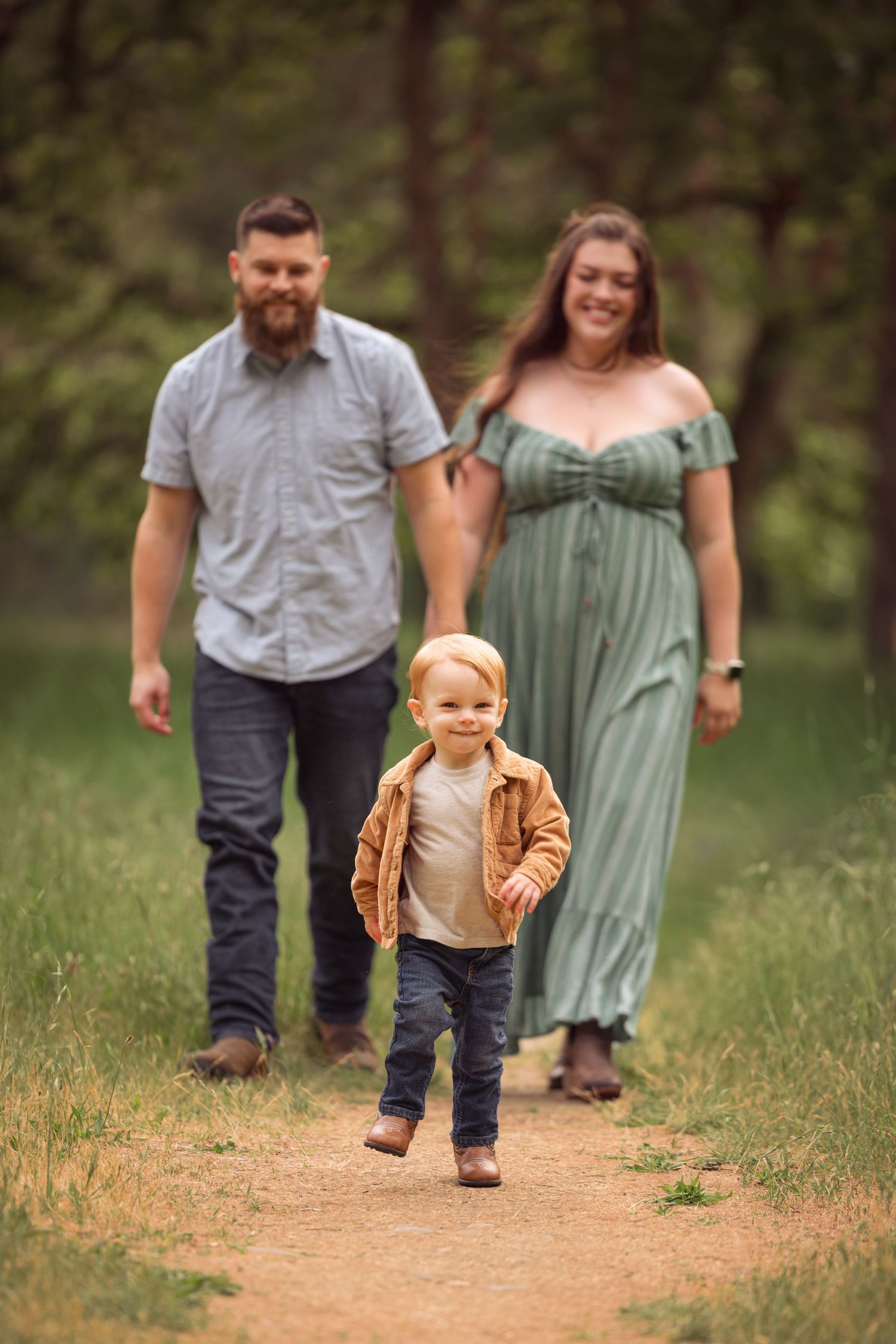 A family walking together on a nature trail during a casual outdoor photo session.
