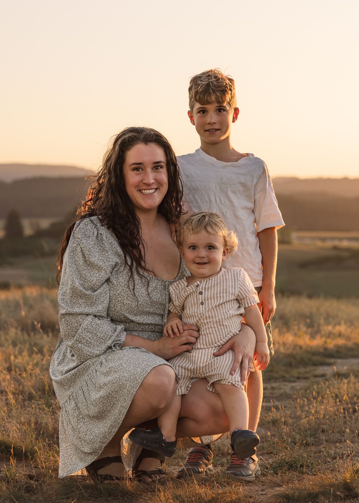 Family portrait session at sunset in a golden field with warm lighting taken by Salem, Oregon family photographer.