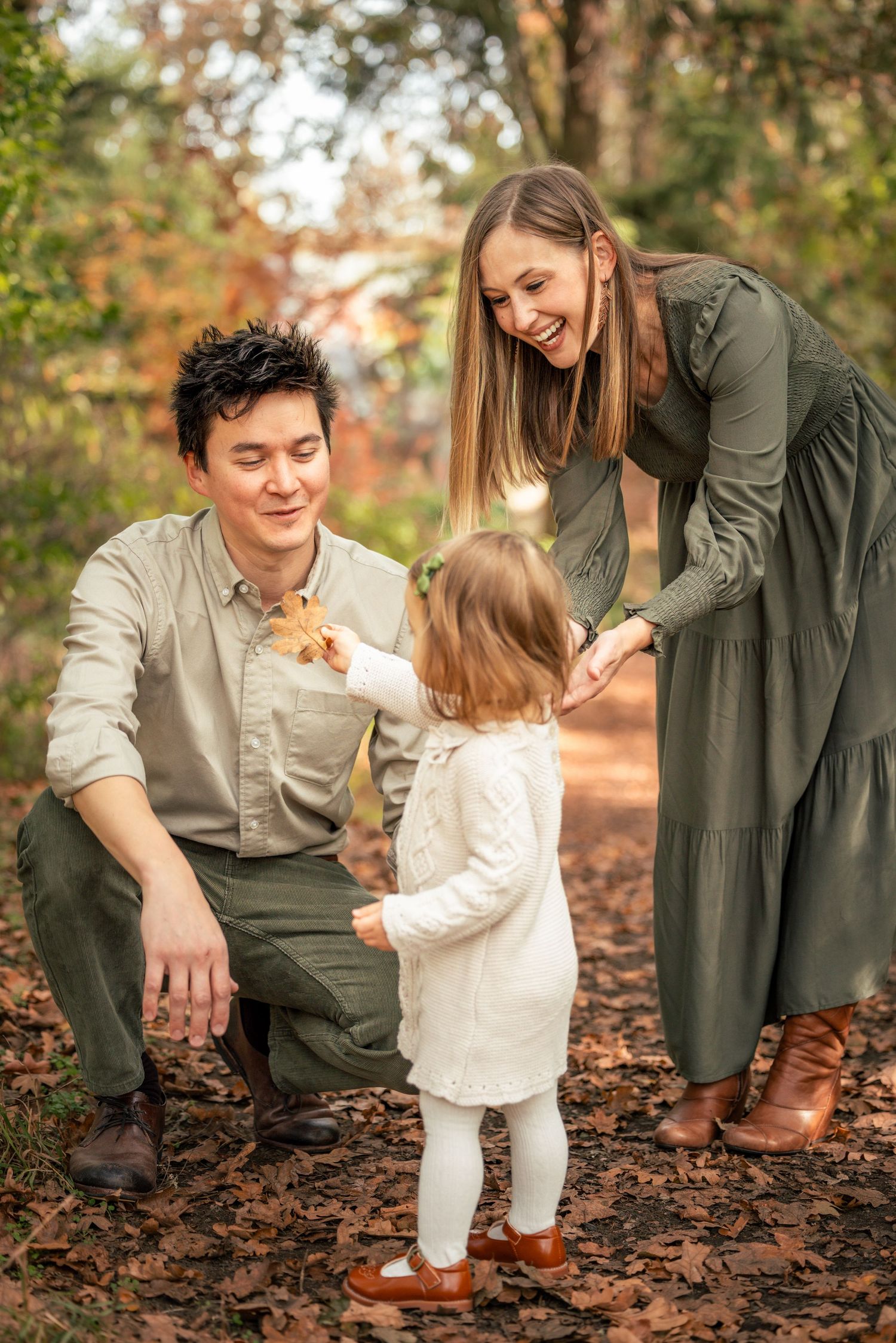 Candid moments captured between parent and child playing in fallen autumn leaves taken by Salem, Oregon family photographer.