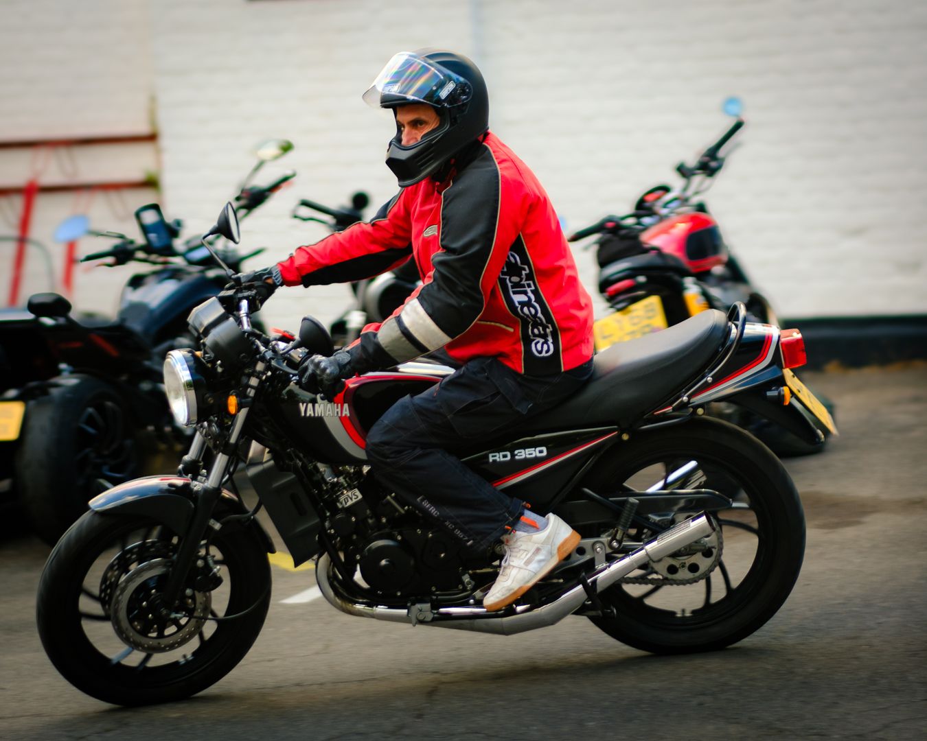 A motorcycle sequence shows a rider in red jacket performing different poses on a dark colored sport bike.