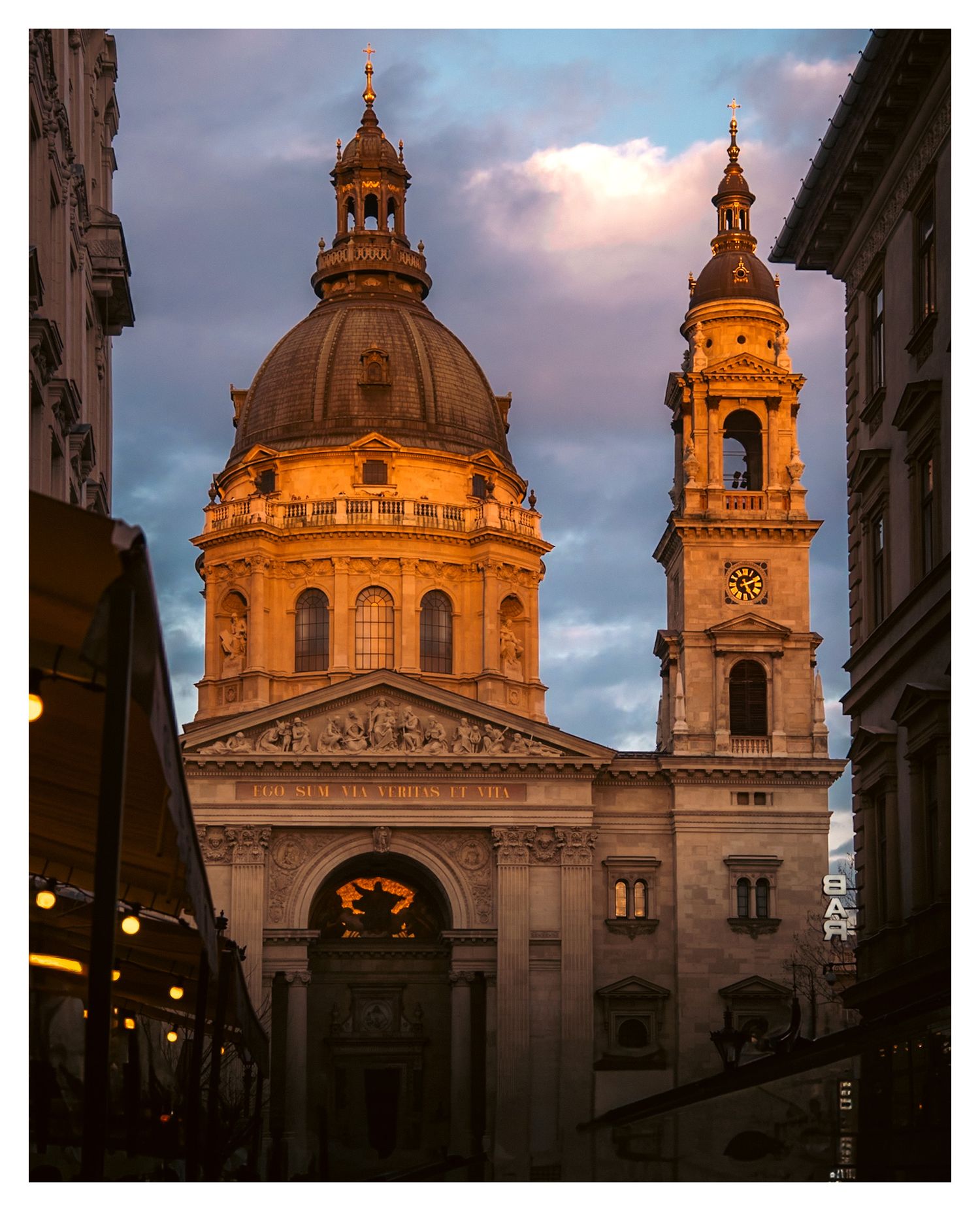 St. Stephen's Basilica glows golden in twilight with its stunning baroque dome and bell tower in Budapest.