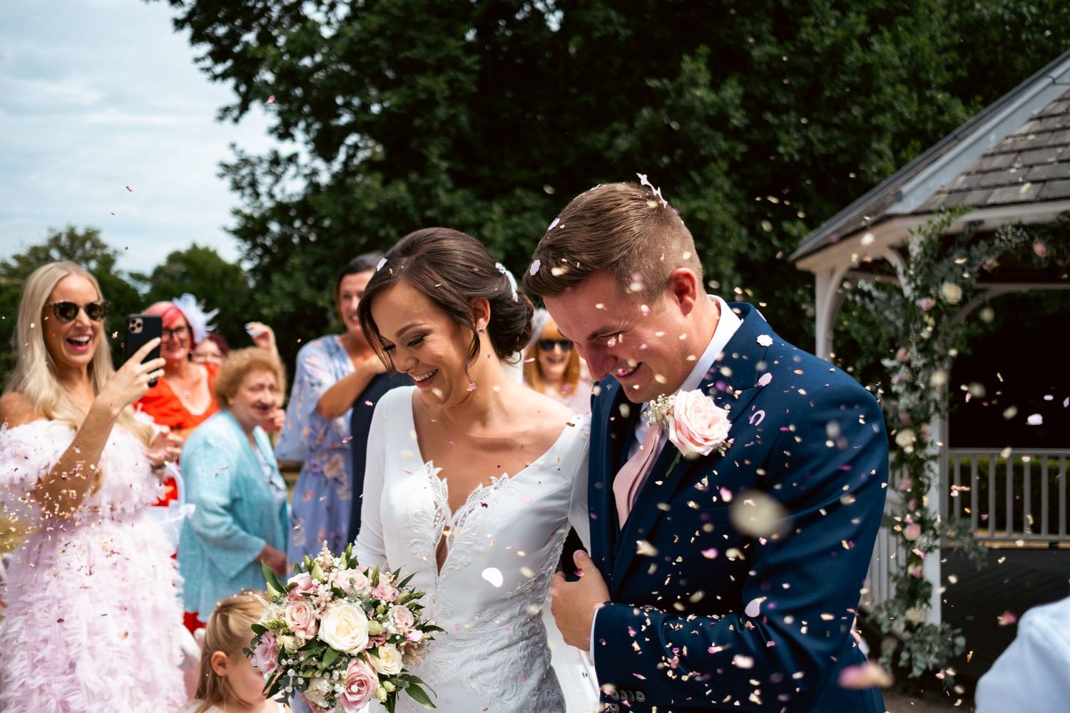 Wedding guests celebrate and dance together joyfully during an outdoor reception celebration.