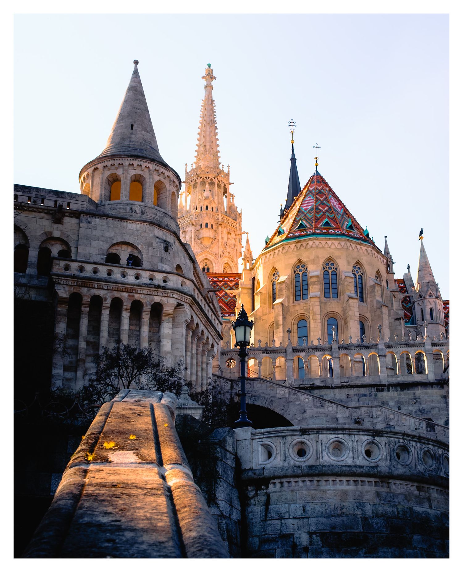 The ornate Fisherman's Bastion in Budapest glows during golden hour, showcasing its neo-Gothic spires and towers.