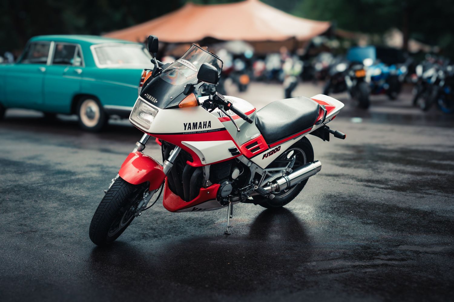 Vintage red and white Yamaha motorcycle displayed on dark pavement in dramatic lighting conditions.