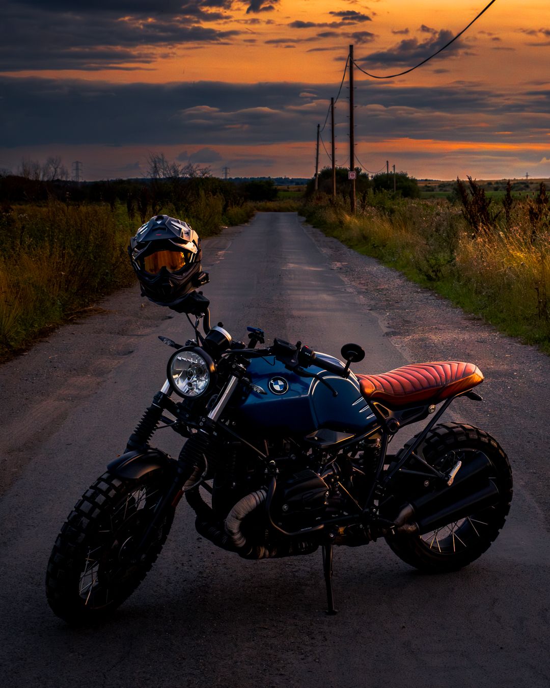 A series of motorcycle silhouettes captured against dramatic orange and purple sunset skies on rural roads.