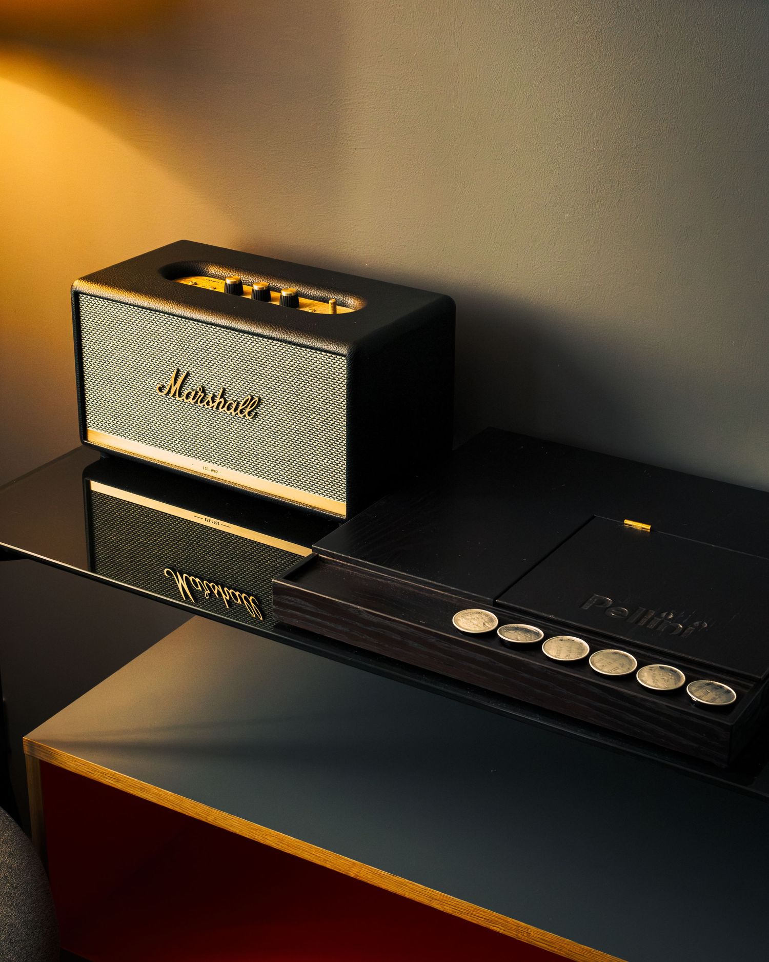 Marshall audio equipment and speakers arranged in a moody lighting setup with golden accents.