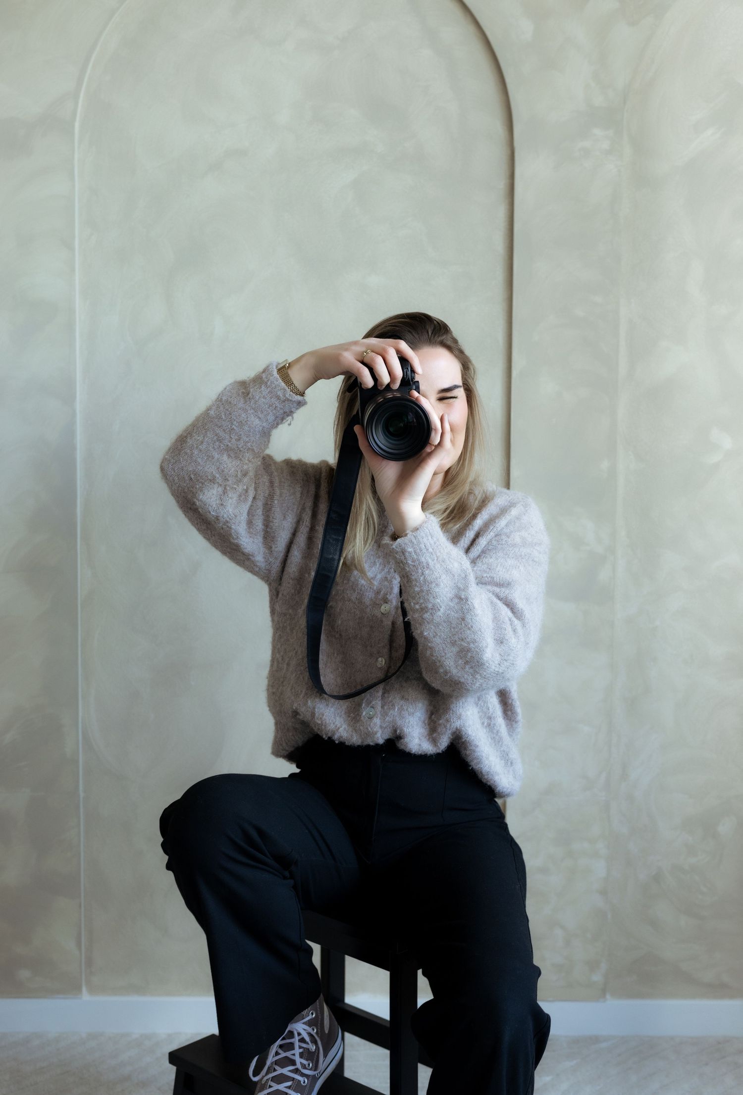 Fotograaf van Myrthegwenfotografie achter de camera, vastgelegd in een professionele en rustige studio-omgeving.