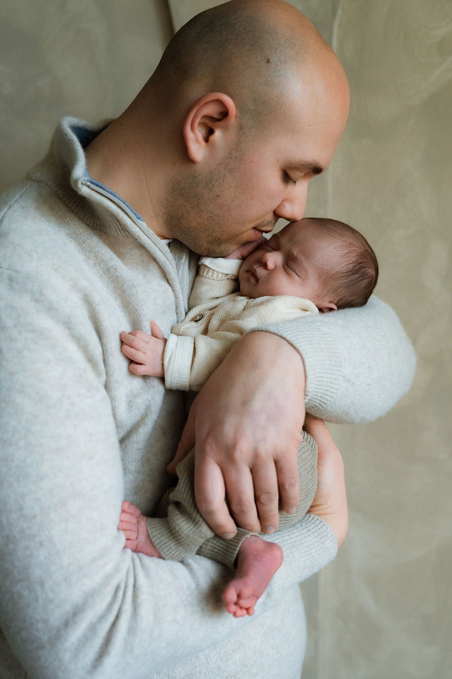 Pasgeboren baby ligt in de handen van vader, liefdevol vastgehouden – Myrthegwen Fotografie Groningen