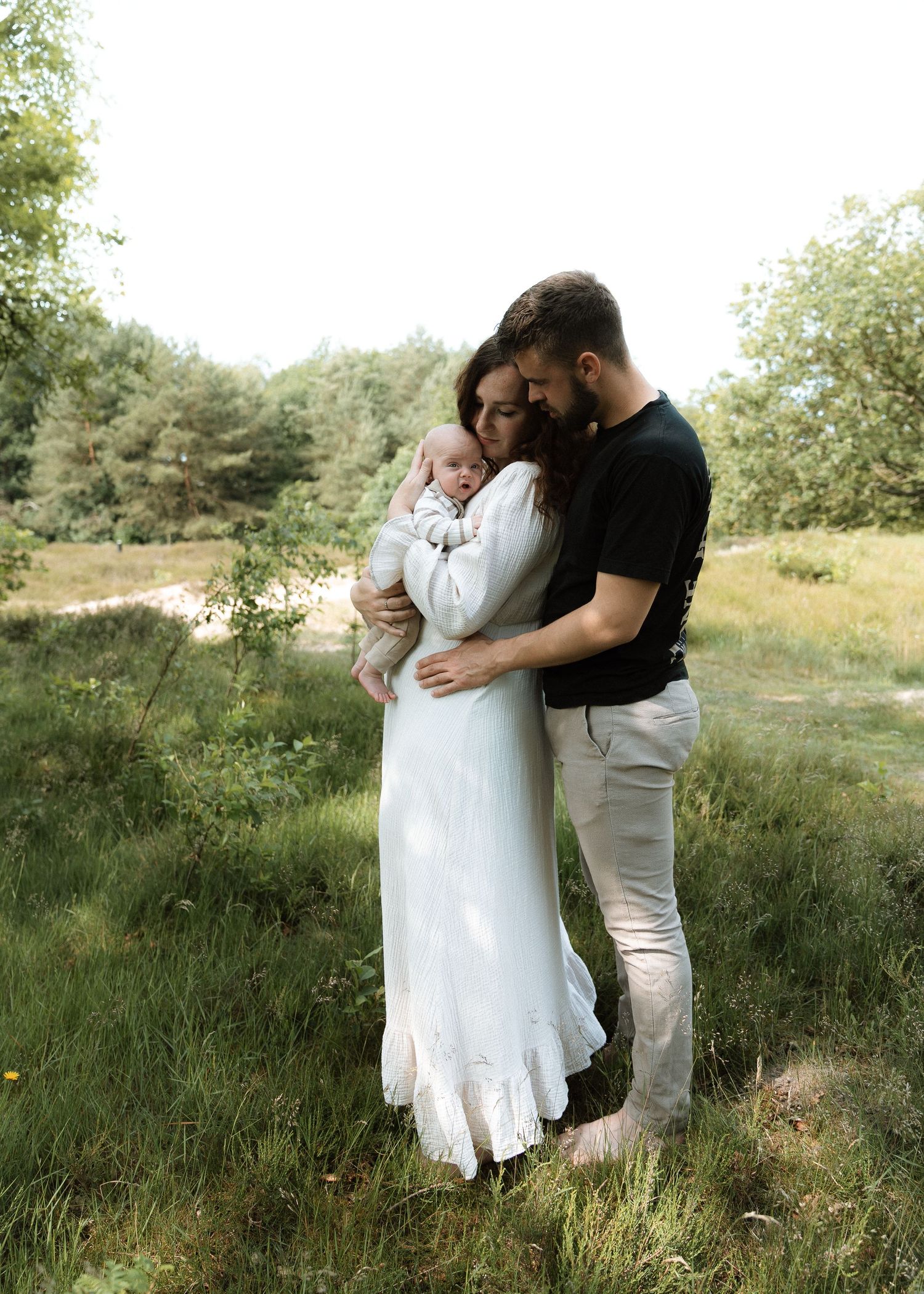 Liefdevolle staande familieportret in de natuur met vader, moeder en kind – Myrthegwen Fotografie Groningen