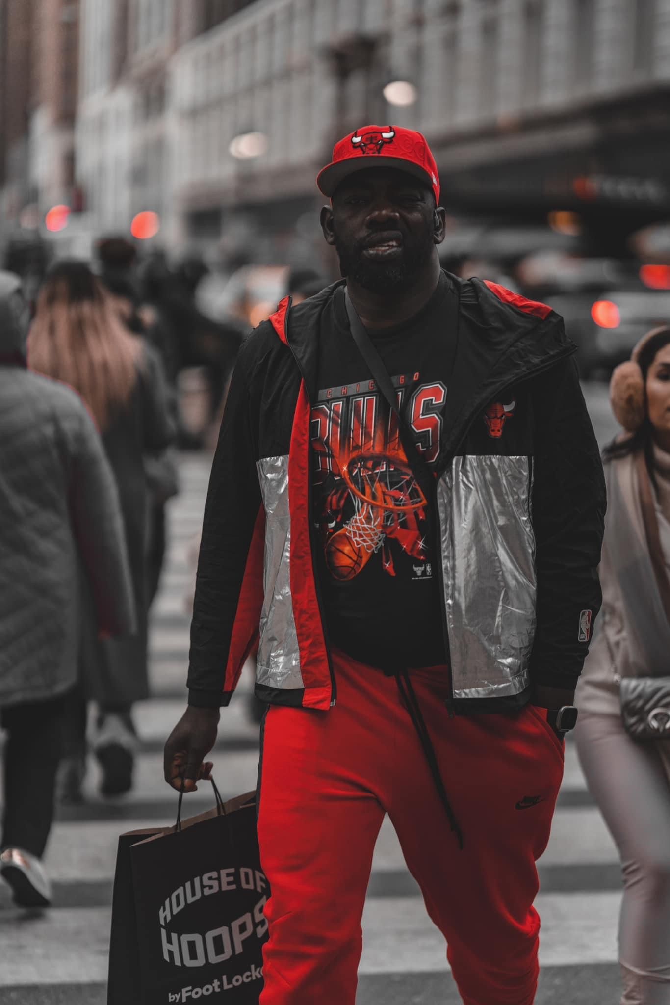 People walking on street wearing red and black urban streetwear clothing.