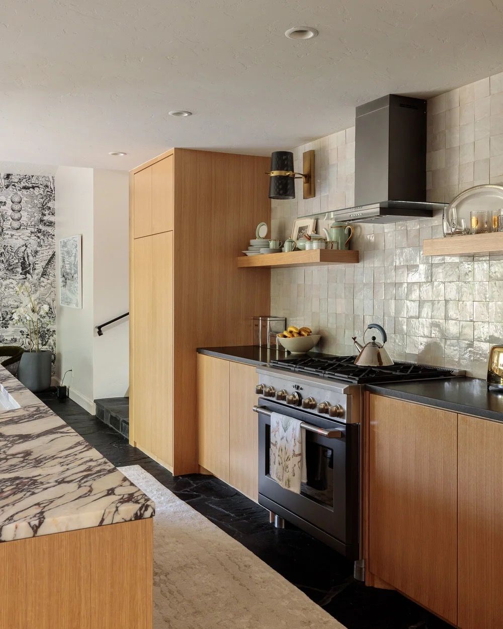 Modern kitchen with wood cabinets, marble countertops, and metallic tile backsplash featuring high-end appliances.
