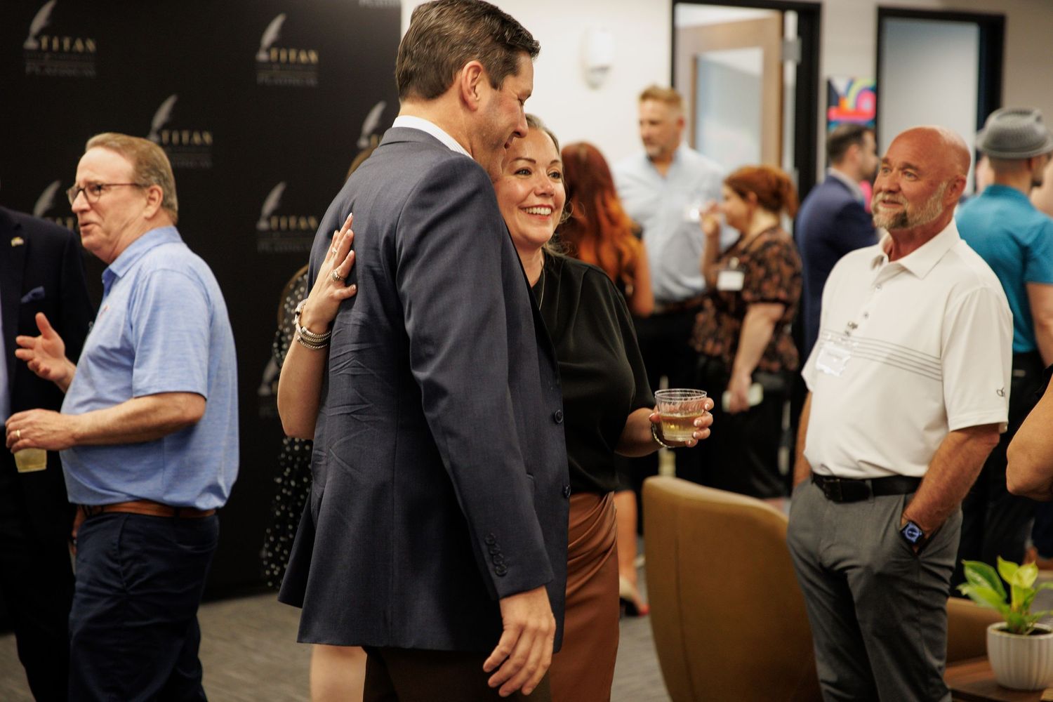 Evening business reception with guests mingling in formal attire.