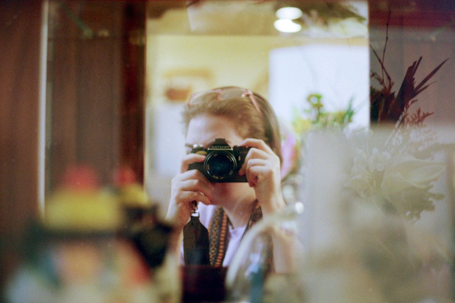 Self portrait in a mirror, we see only the camera and part of her face.