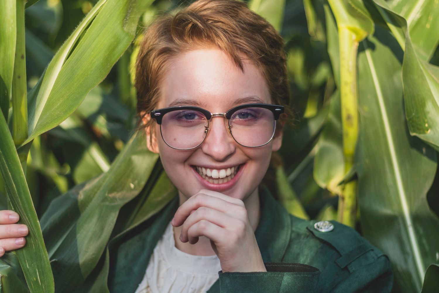 Senior chuckles in a field of corn.