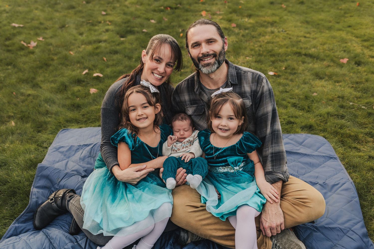 Portrait of a new family of five, featuring mom, dad, two toddlers and their new baby.