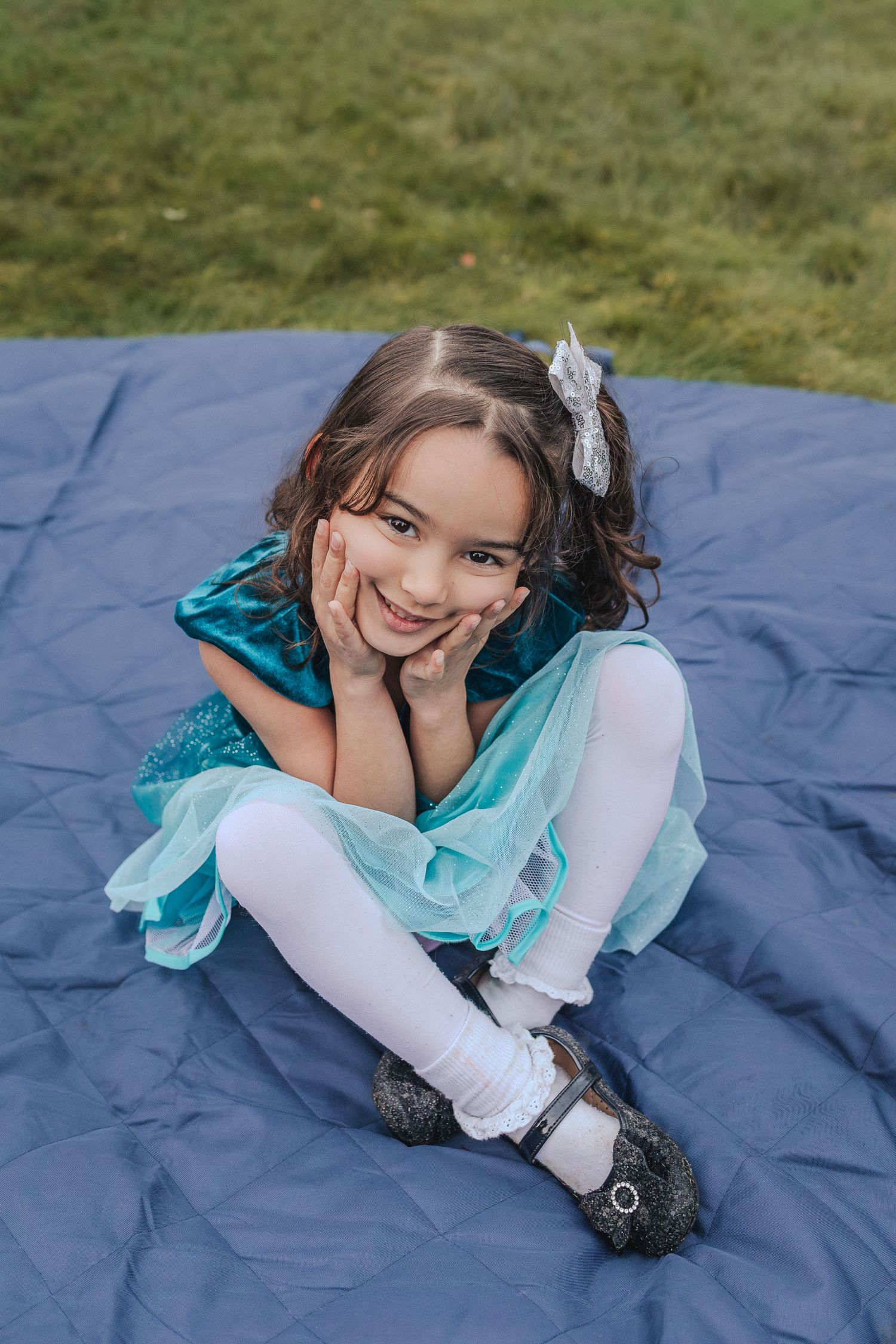 5 year old smiles in her shiny blue dress