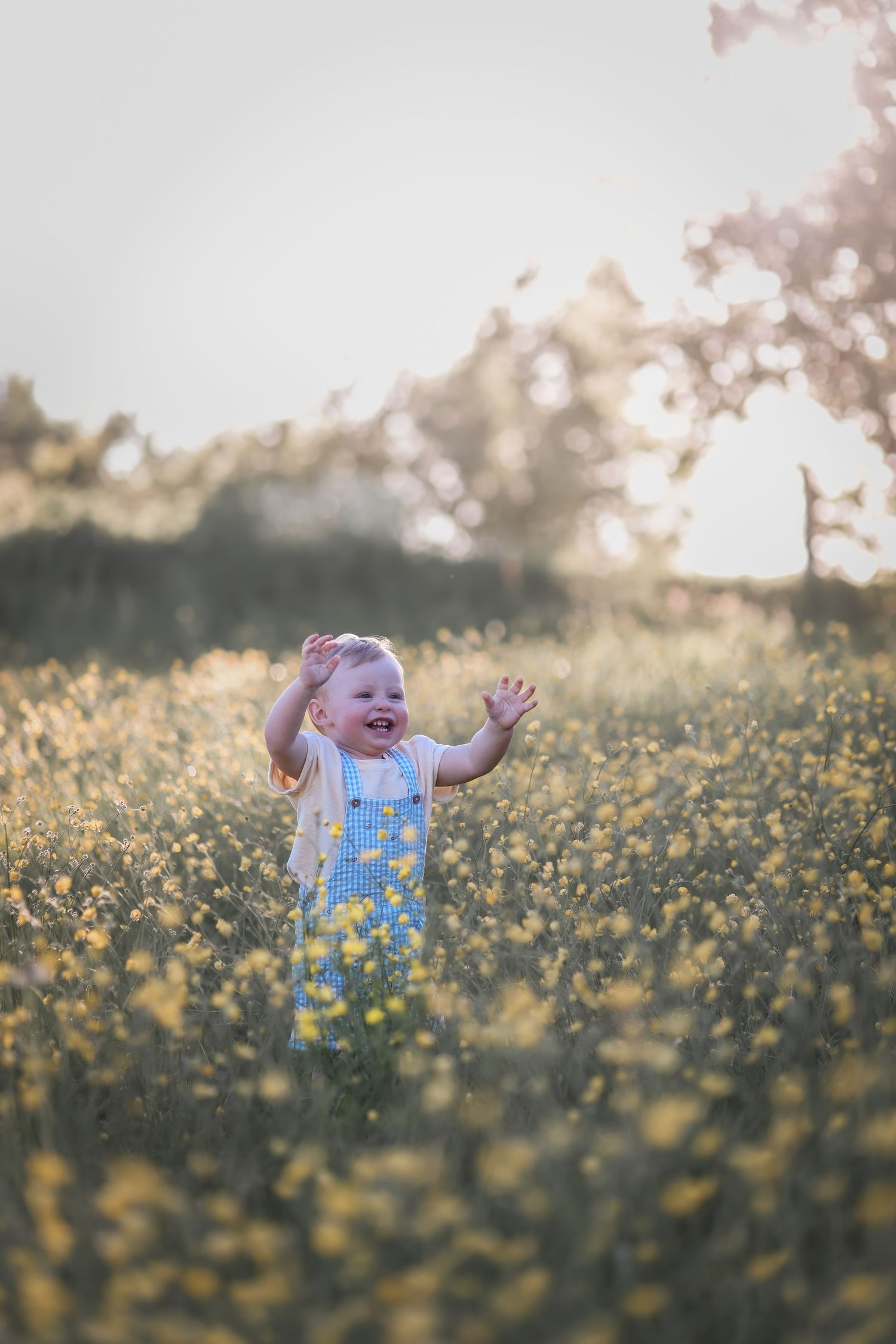 Barnfotografering i Uddevalla bland blommande smörblommor. Fotograf: SLfotografi I Västra Götaland.