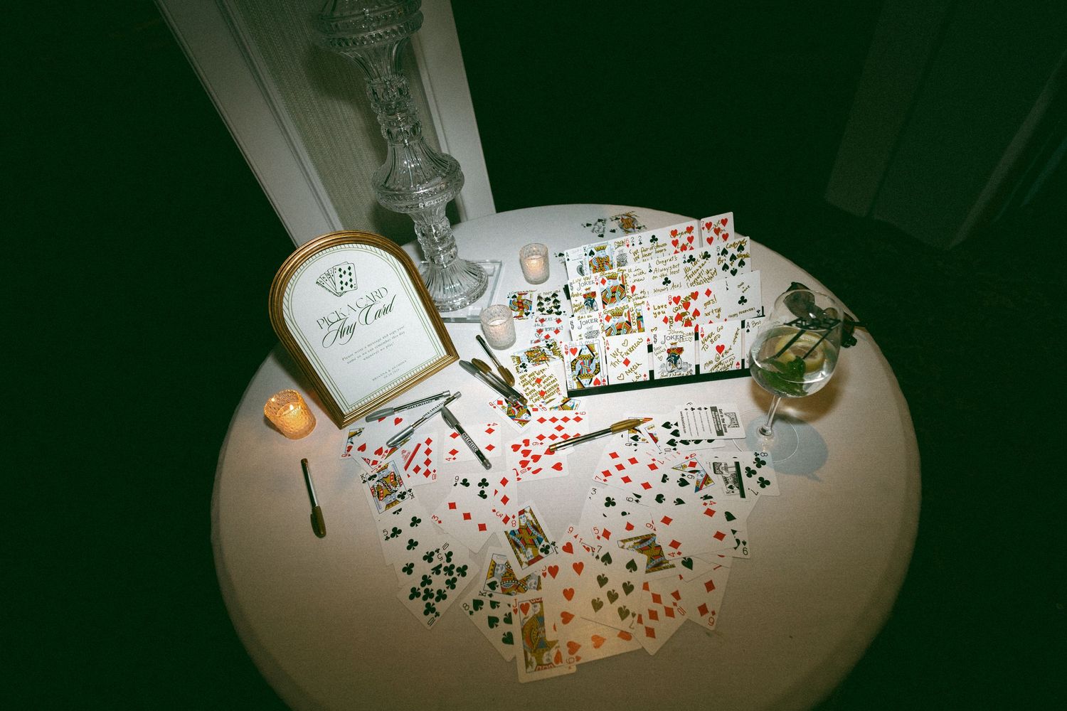 Overhead view of playing cards and poker chips spread across a round table at a wedding reception.