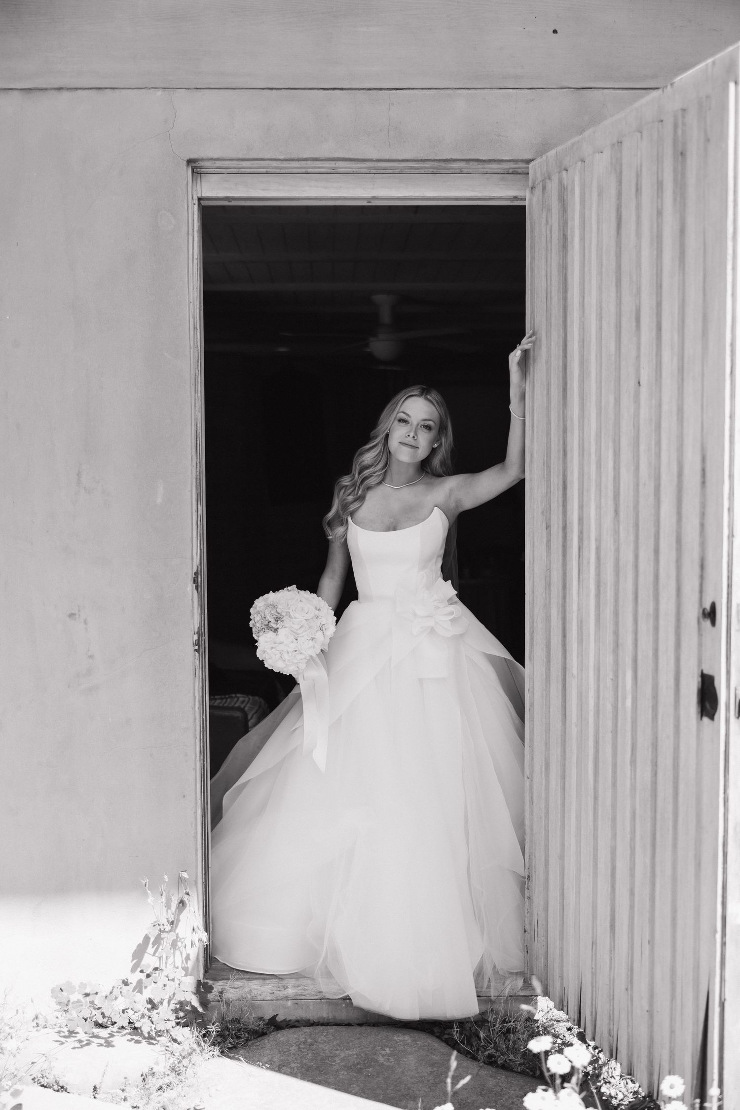 Wedding dresses displayed in a row of white wooden closets or changing rooms.