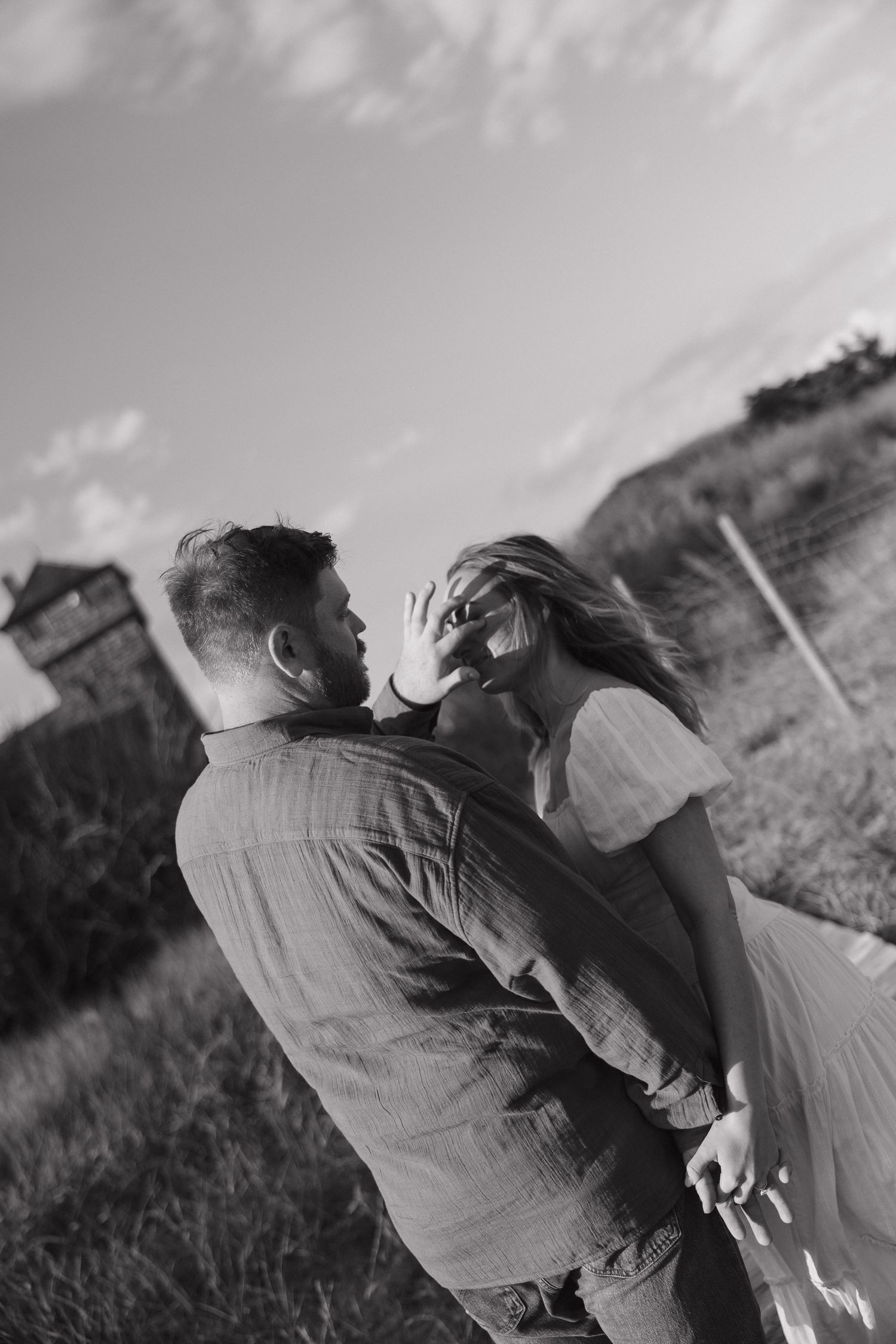Black and white series of a couple embracing in a natural outdoor setting.