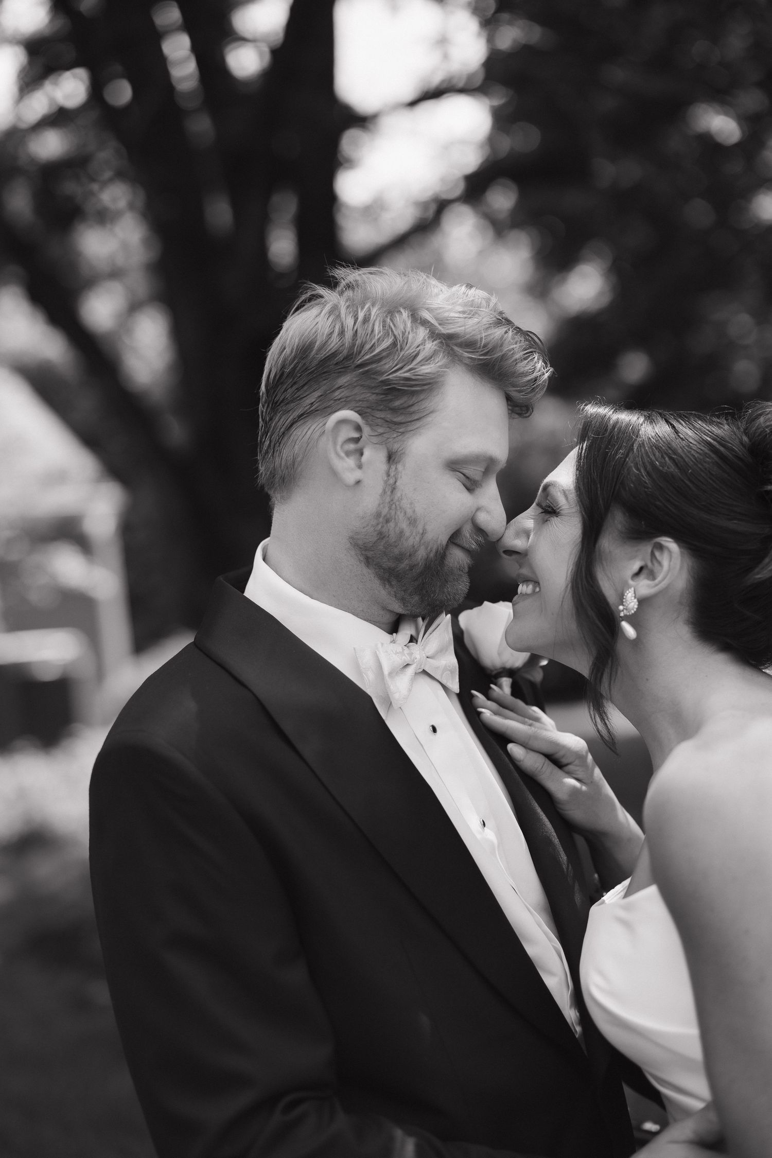 Intimate black and white portrait of newlyweds sharing a tender moment.