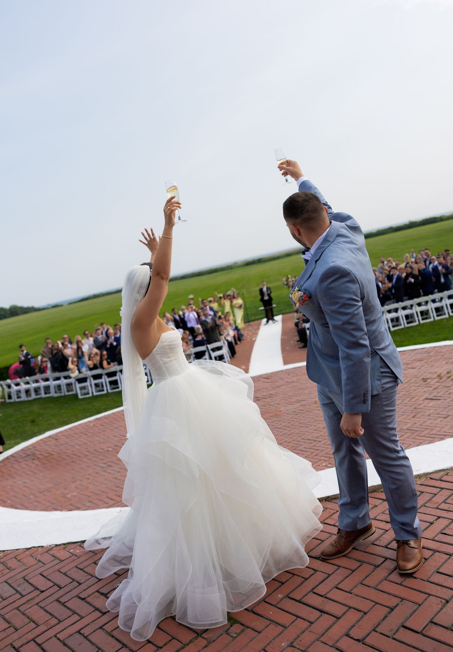 A series of photos showing a couple dancing at their outdoor wedding reception on a brick patio with guests watching.