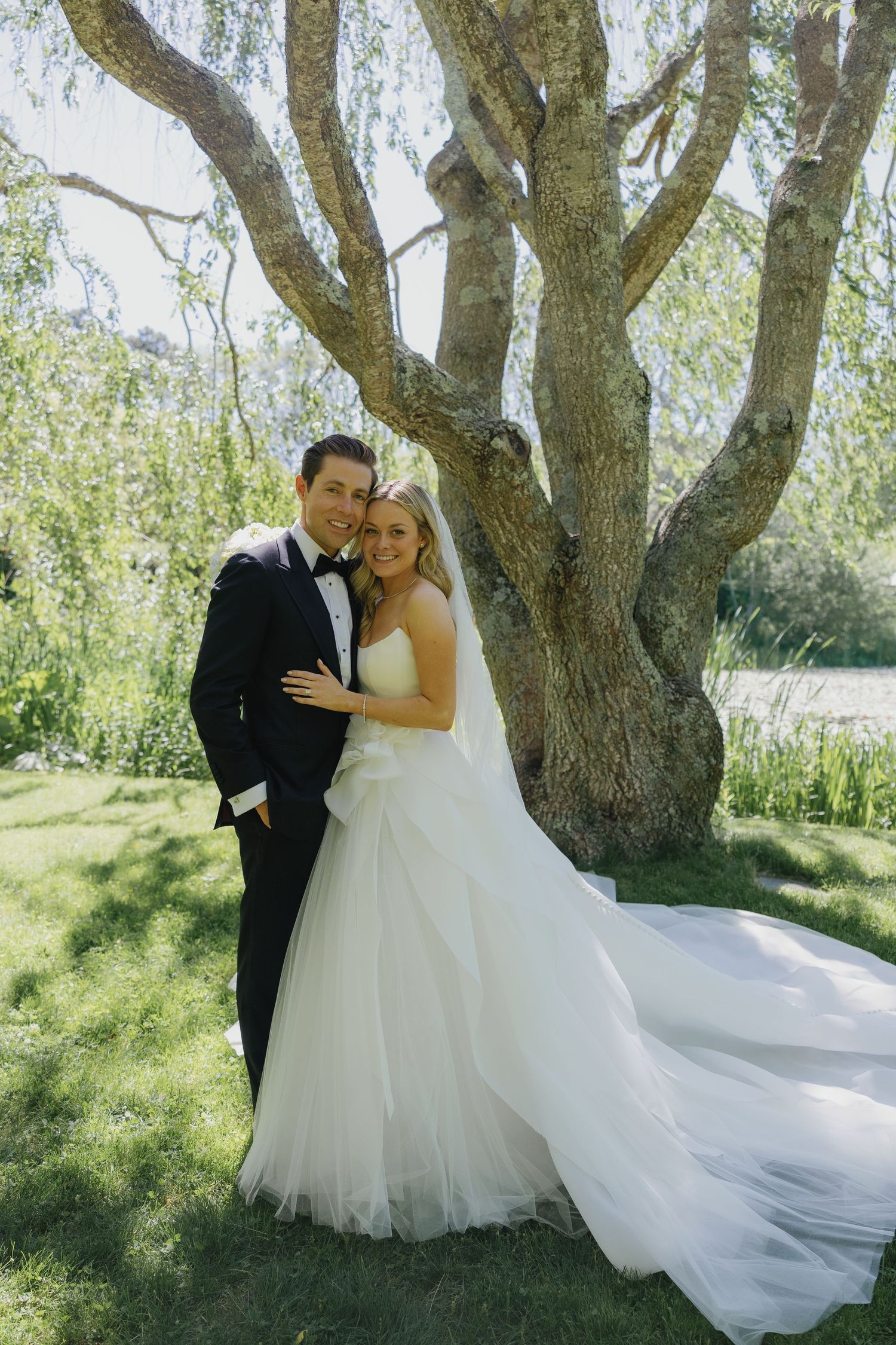 A romantic wedding photo series under a majestic weeping willow tree on a sunny day.