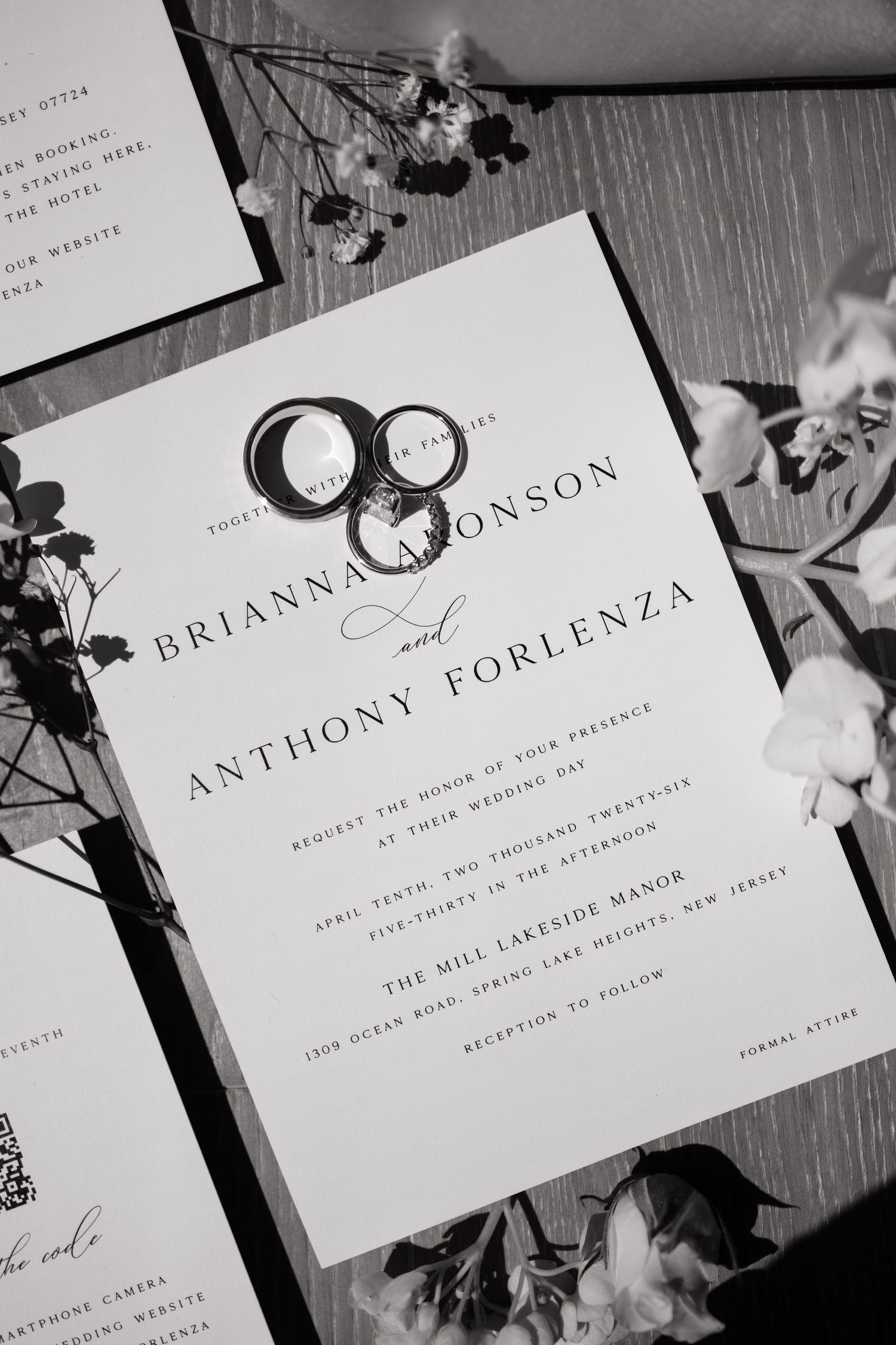 Black and white wedding invitation for Brianna Aronson and Anthony Forlenza with rings at Mill Lakeside Manor.