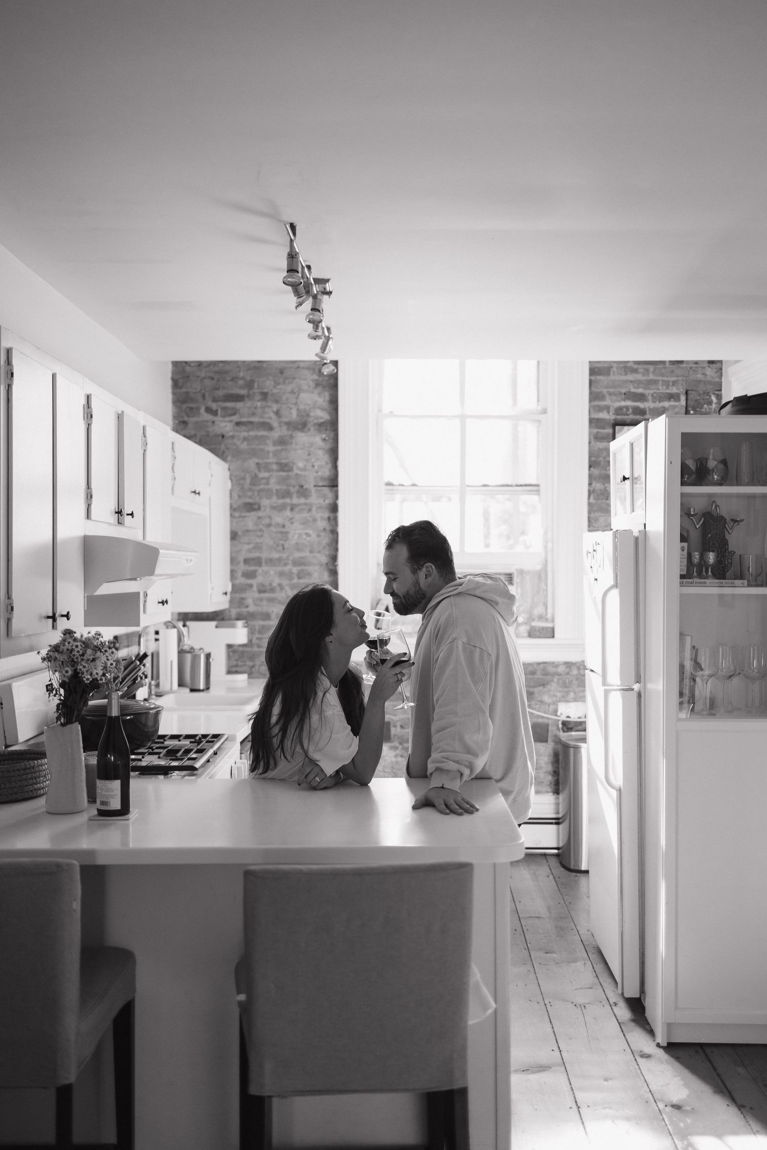 Candid black and white sequence of couple in modern kitchen interior.