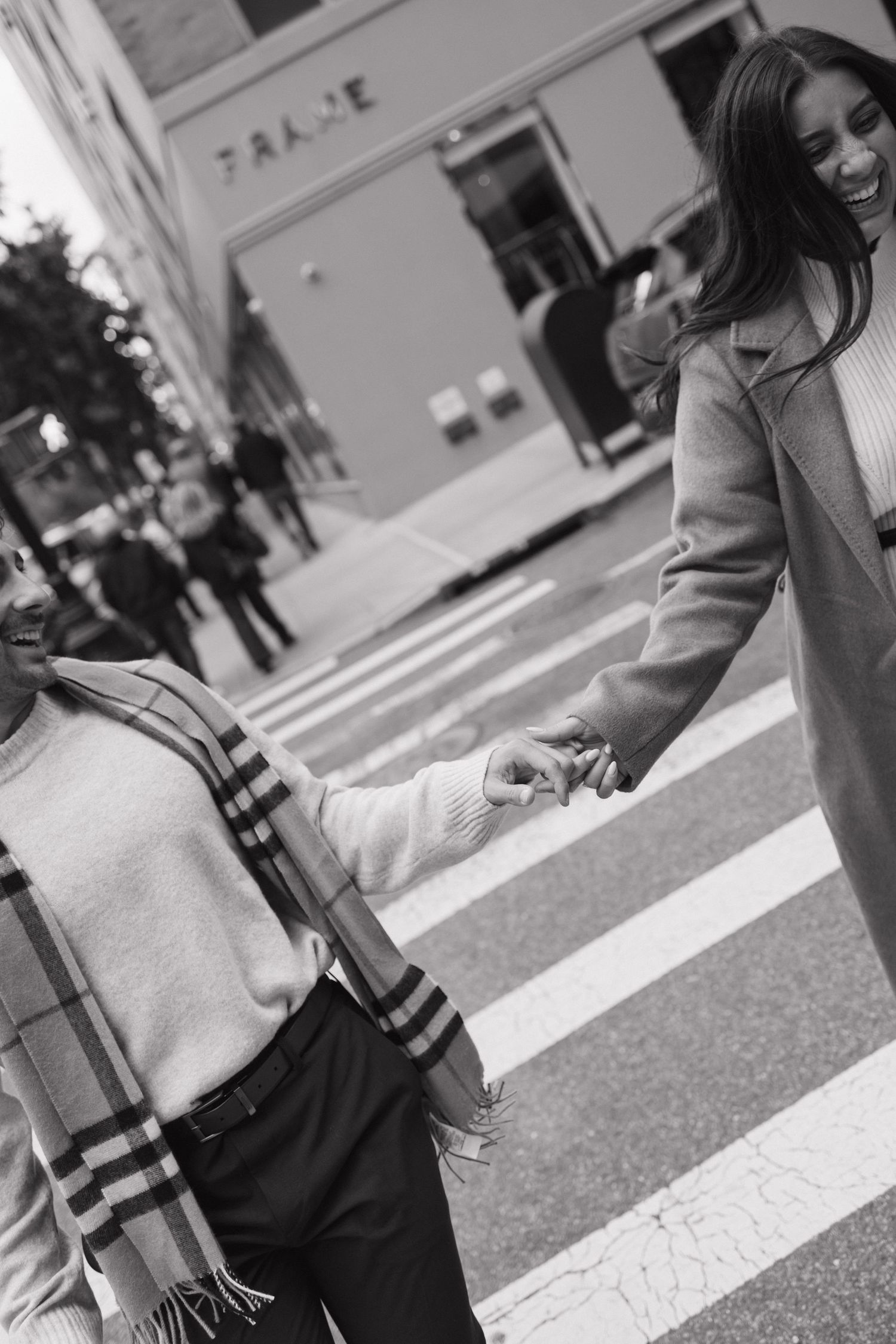 Close-up black and white shots of people crossing a city street wearing patterned clothing.