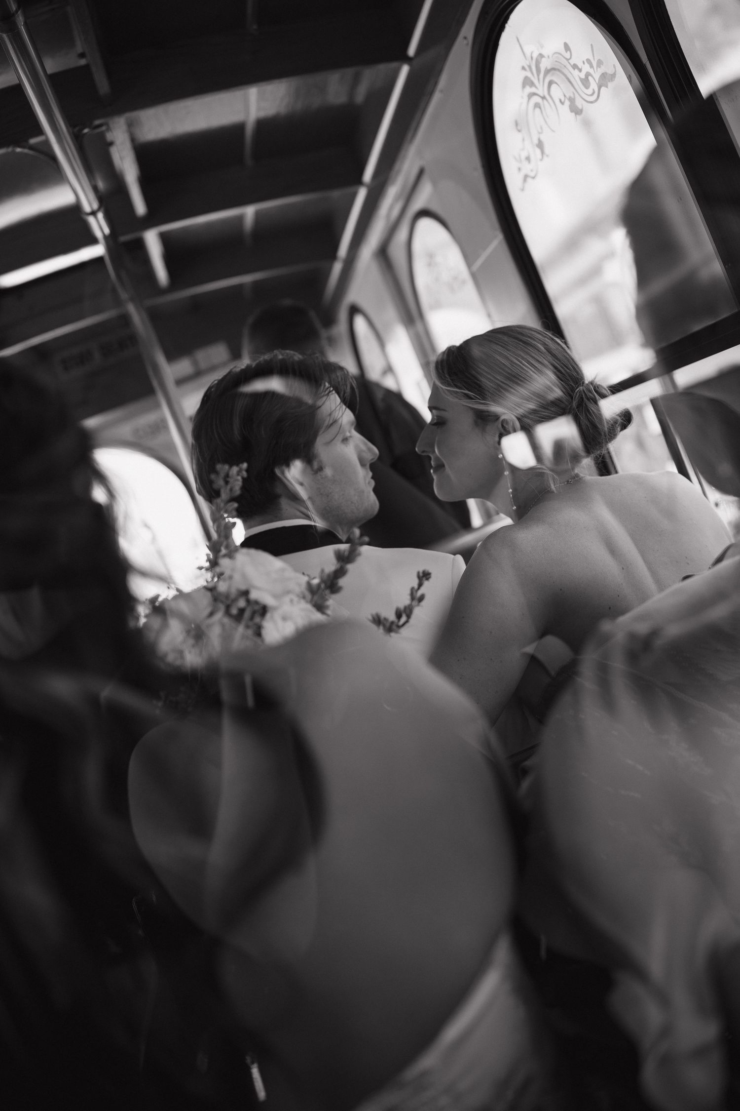 Black and white photograph showing guests seated inside a dimly lit event venue.