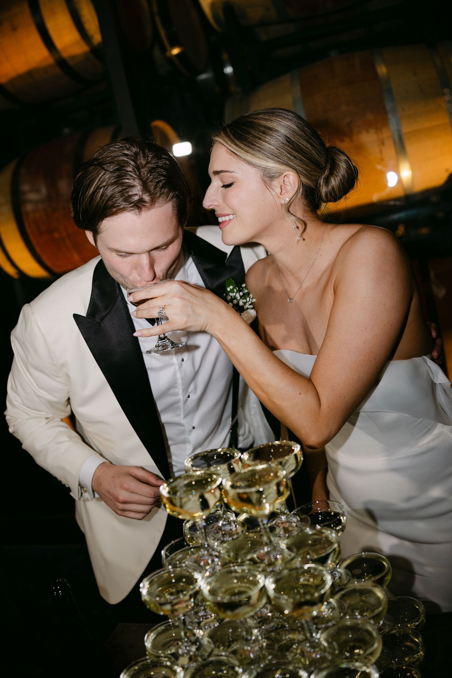 Bride and groom sharing champagne together during wedding reception.