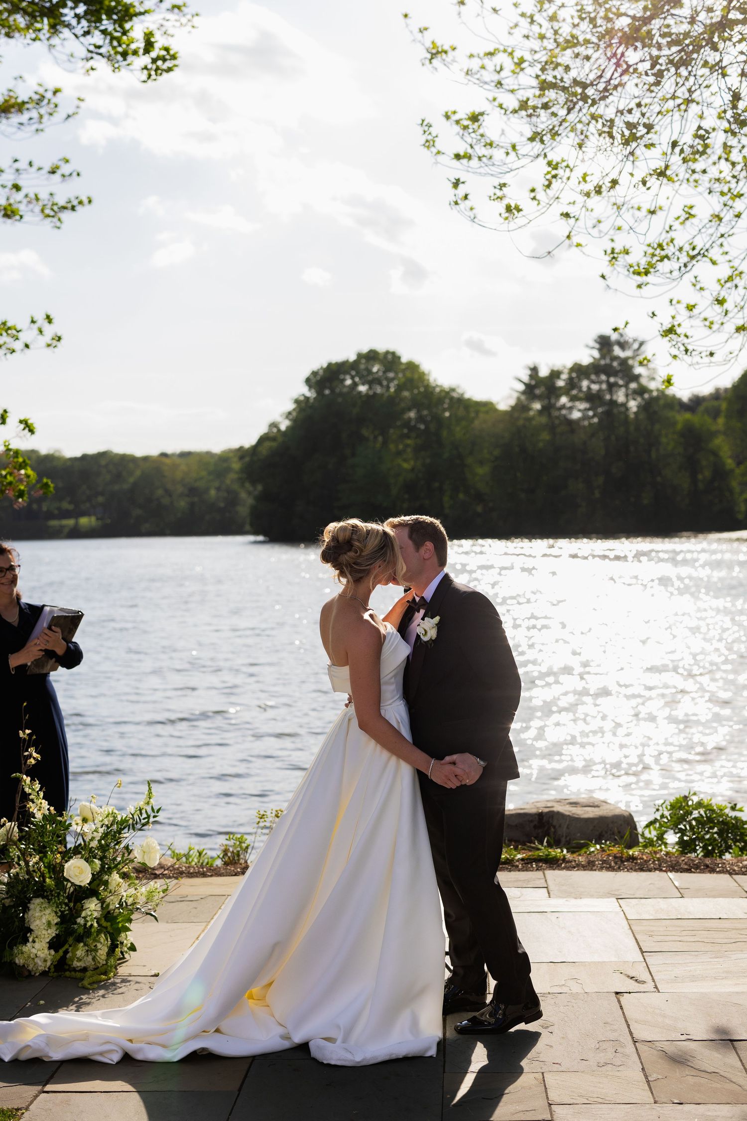 Wedding couple sharing an intimate moment by a serene lakeside setting.